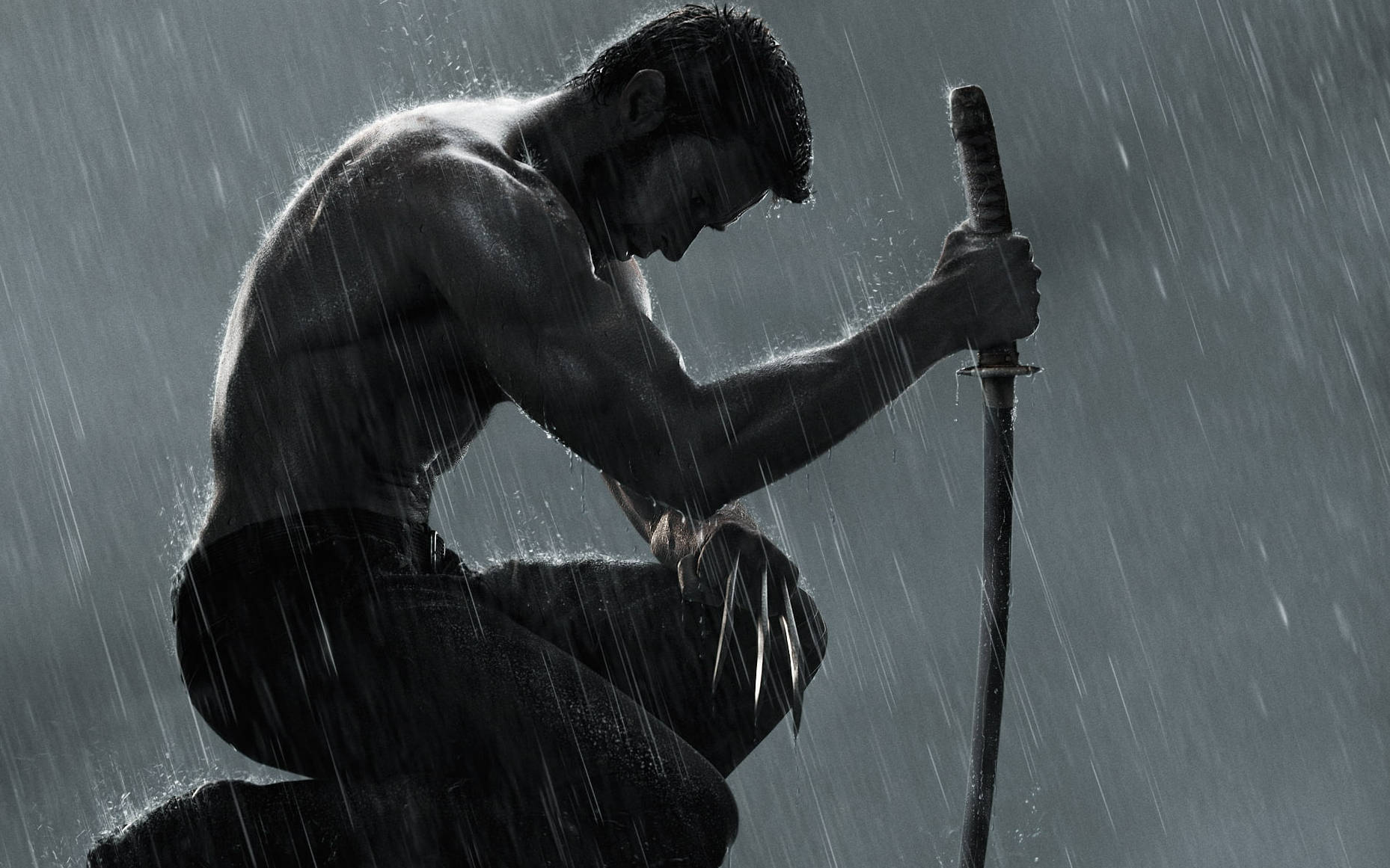 Hugh Jackman 桌布 壁紙 — 一個肌肉發達的男人在傾盆大雨中跪著，緊握著劍，伸出爪子，雨水順著他的身體流下，形成一個戲劇性的黑白場景。