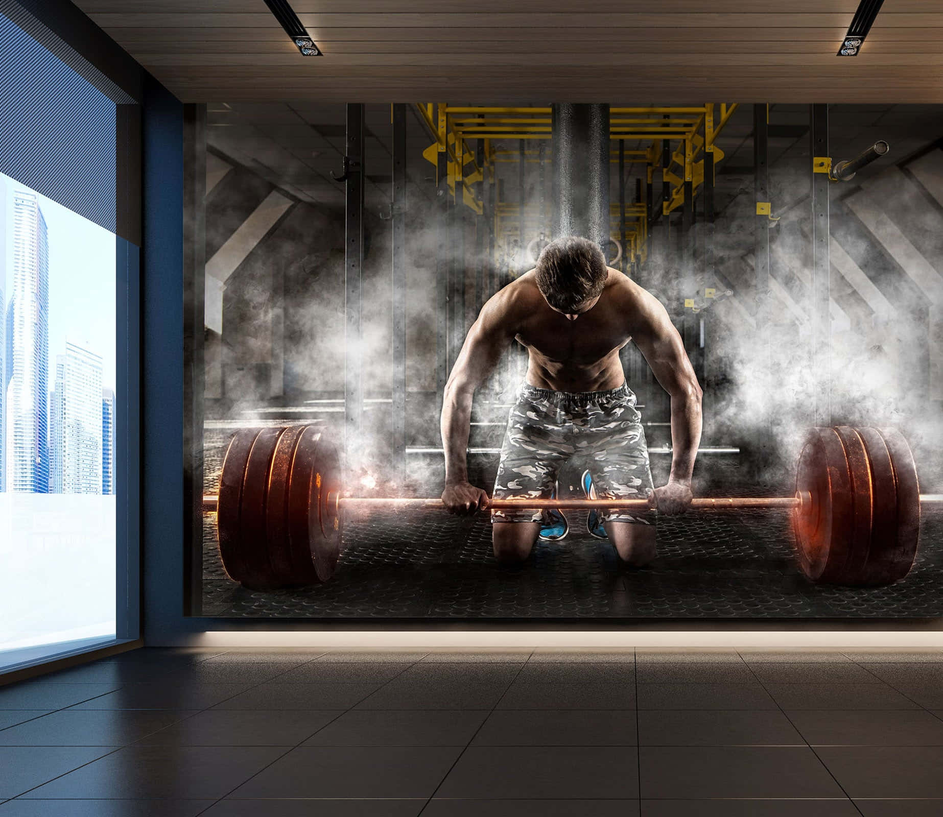 Barbell 桌布 壁紙 — 一個肌肉發達的男人跪著，抓住一個沉重的槓鈴，在煙霧瀰漫的健身房裡，透過大窗戶可以看到城市摩天大樓。