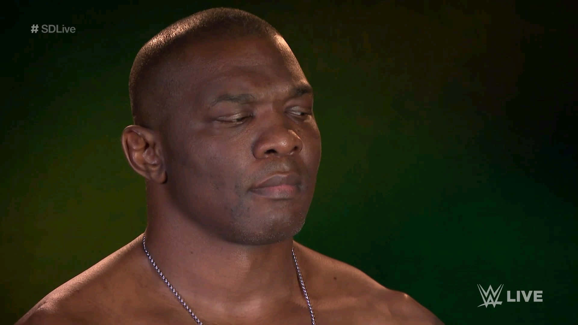 WWE 桌布 壁紙 — 一個肌肉發達的男人閉著眼睛，戴著銀鏈，在WWE直播中靠著深綠色背景休息。