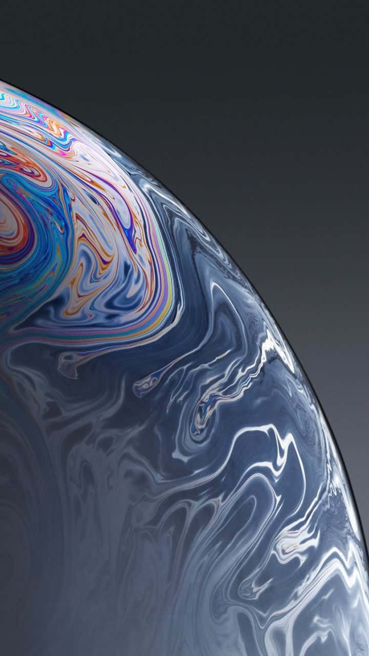 Blue iPhone Xr 桌布 壁紙 — 一個肥皂泡的虹彩表面在深色漸變背景上旋轉著鮮豔彩虹色的特寫。