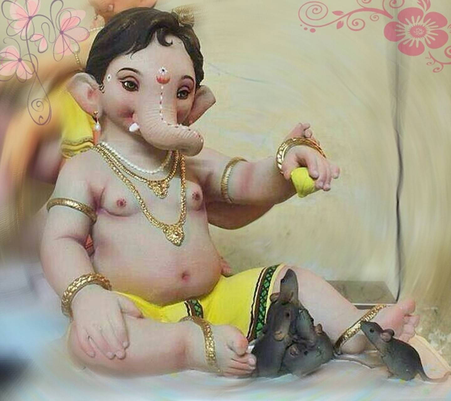 Hindu God 桌布 壁紙 — 一個胖乎乎的嬰兒象頭神，飾有黃金首飾，盤腿而坐，腳邊有老鼠，手裡拿著一個黃色的球。
