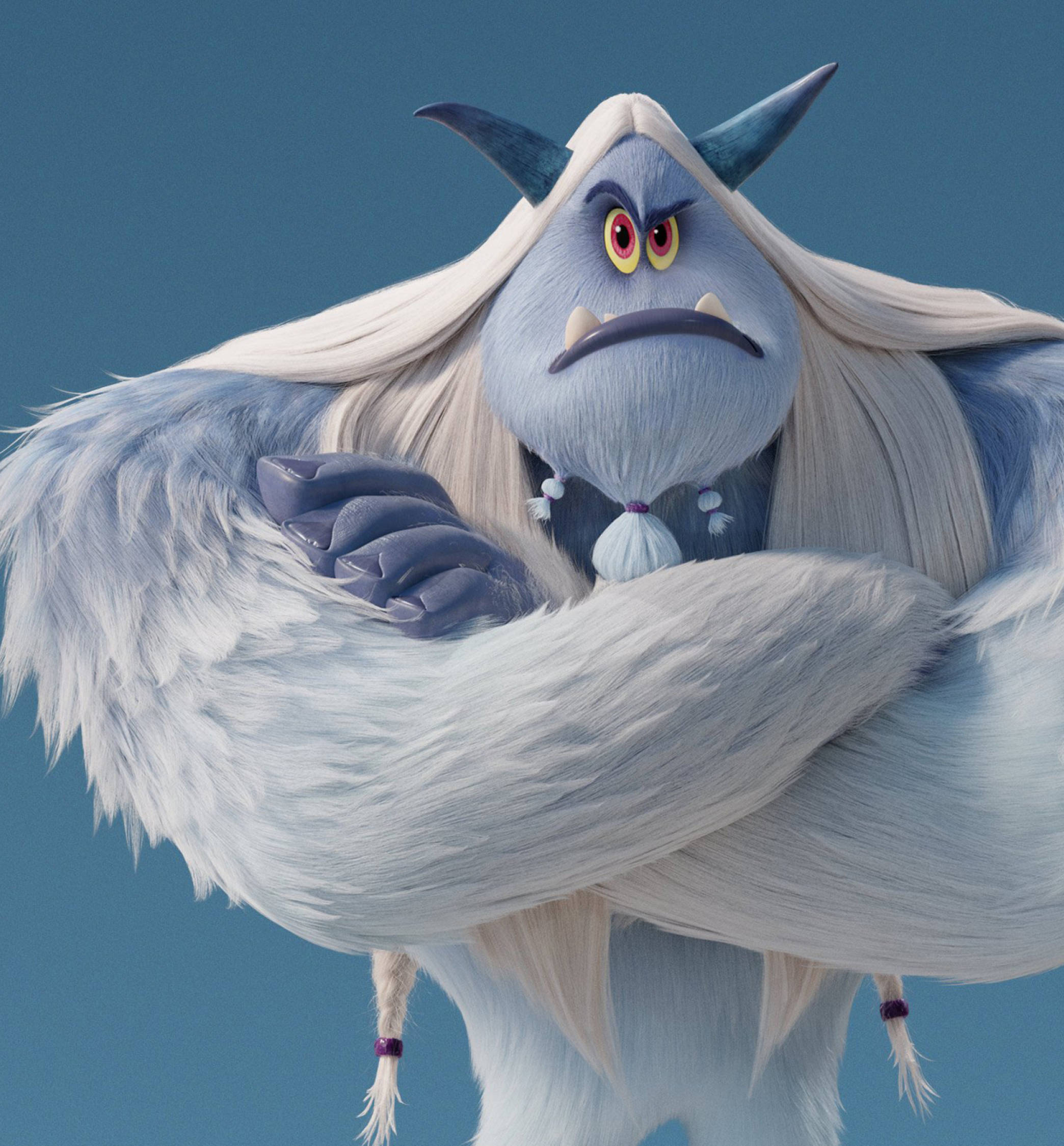 Smallfoot 桌布 壁紙 — 一個脾氣暴躁的藍色雪人，長著白色長髮和角，雙臂交叉站在純藍色背景前。