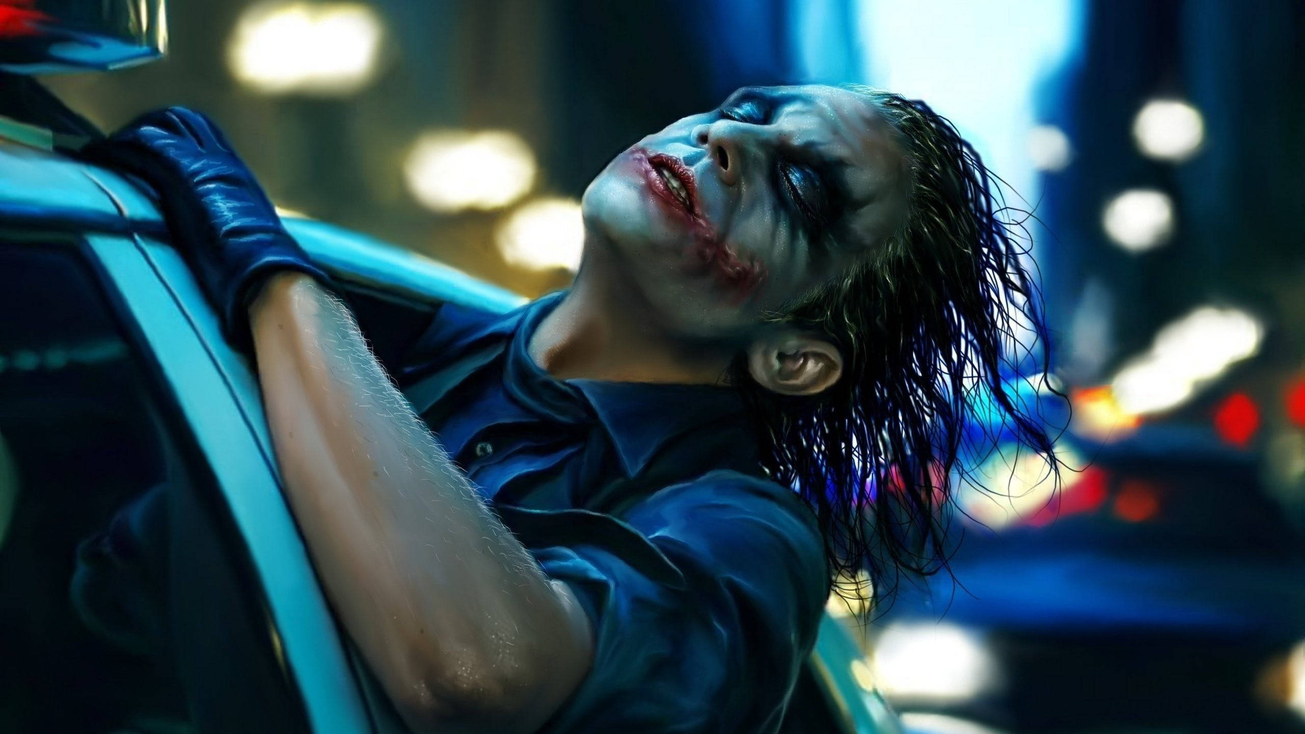 Heath Ledger Joker 桌布 壁紙 — 一個臉上塗著白色顏料、嘴唇紅色的男人在夜晚霓虹燈閃爍的城市中靠著一輛車。