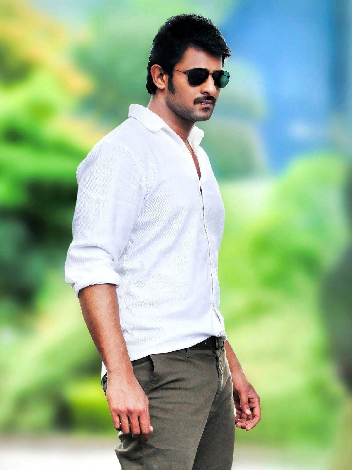 Prabhas Mirchi 桌布 壁紙 — 一個自信的男人，穿著白襯衫和太陽眼鏡，站在充滿活力的綠色模糊背景前。