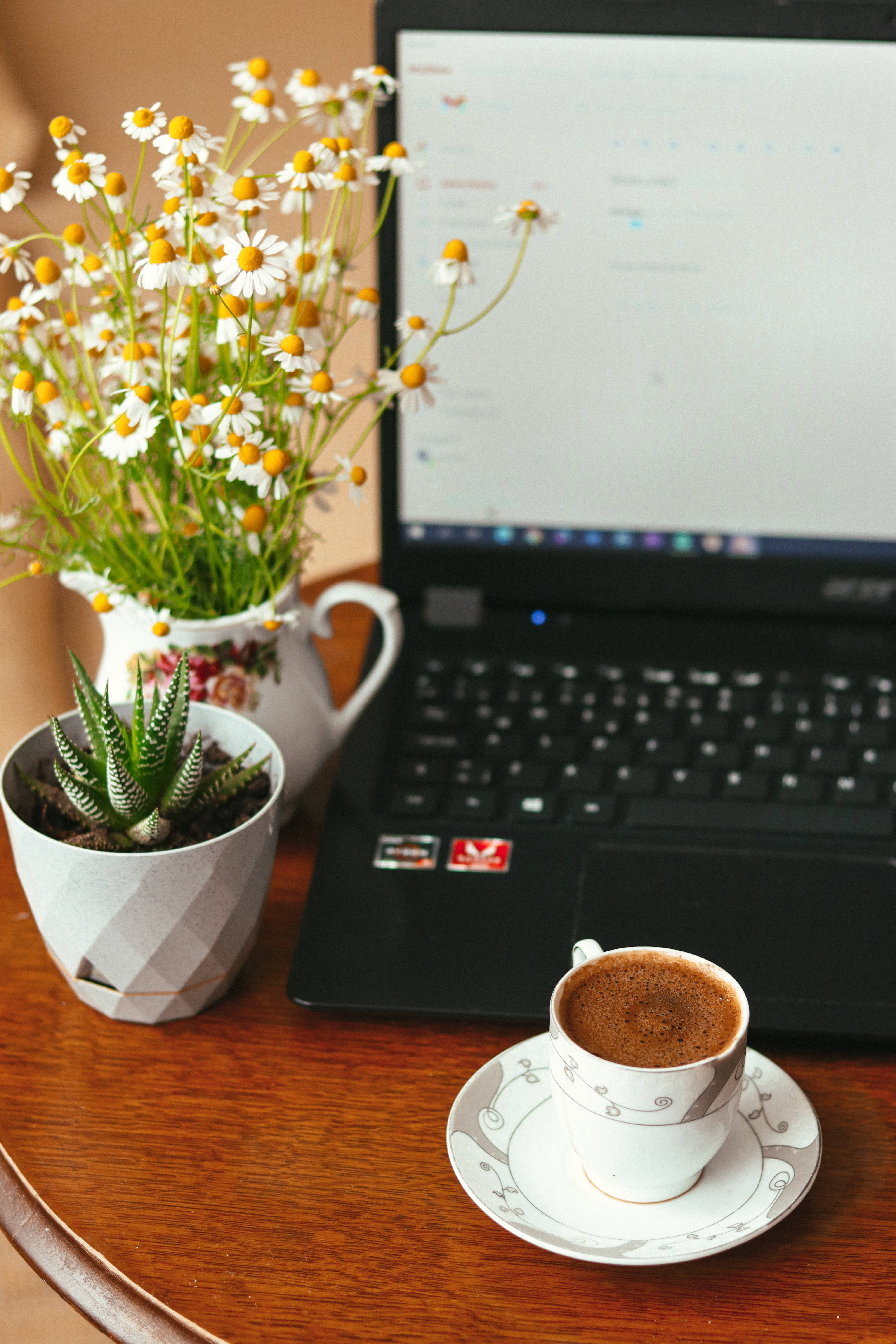 aesthetic tumblr laptop 桌布 壁紙 — 一個舒適的工作空間，配有筆記型電腦、冒煙的咖啡、花瓶中的雛菊和木桌上的多肉植物。