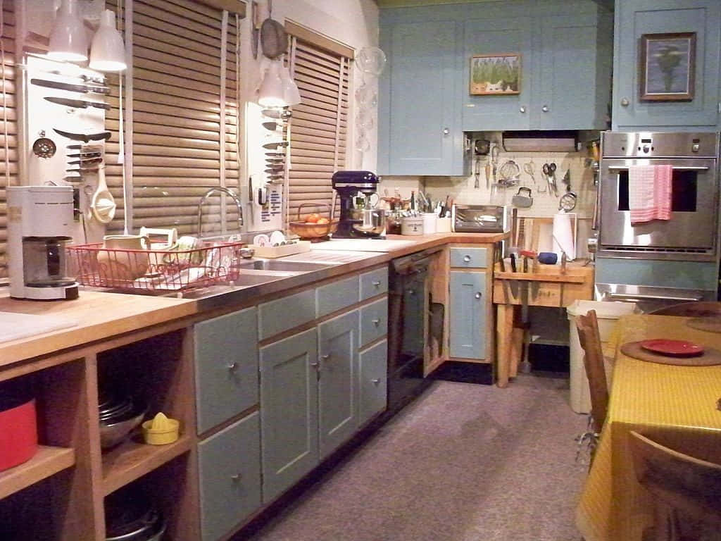 kitchen 桌布 壁紙 — 一個舒適的廚房，配有淺藍色櫥櫃、木質檯面和溫暖的燈光，營造出充滿生活氣息的居家氛圍。