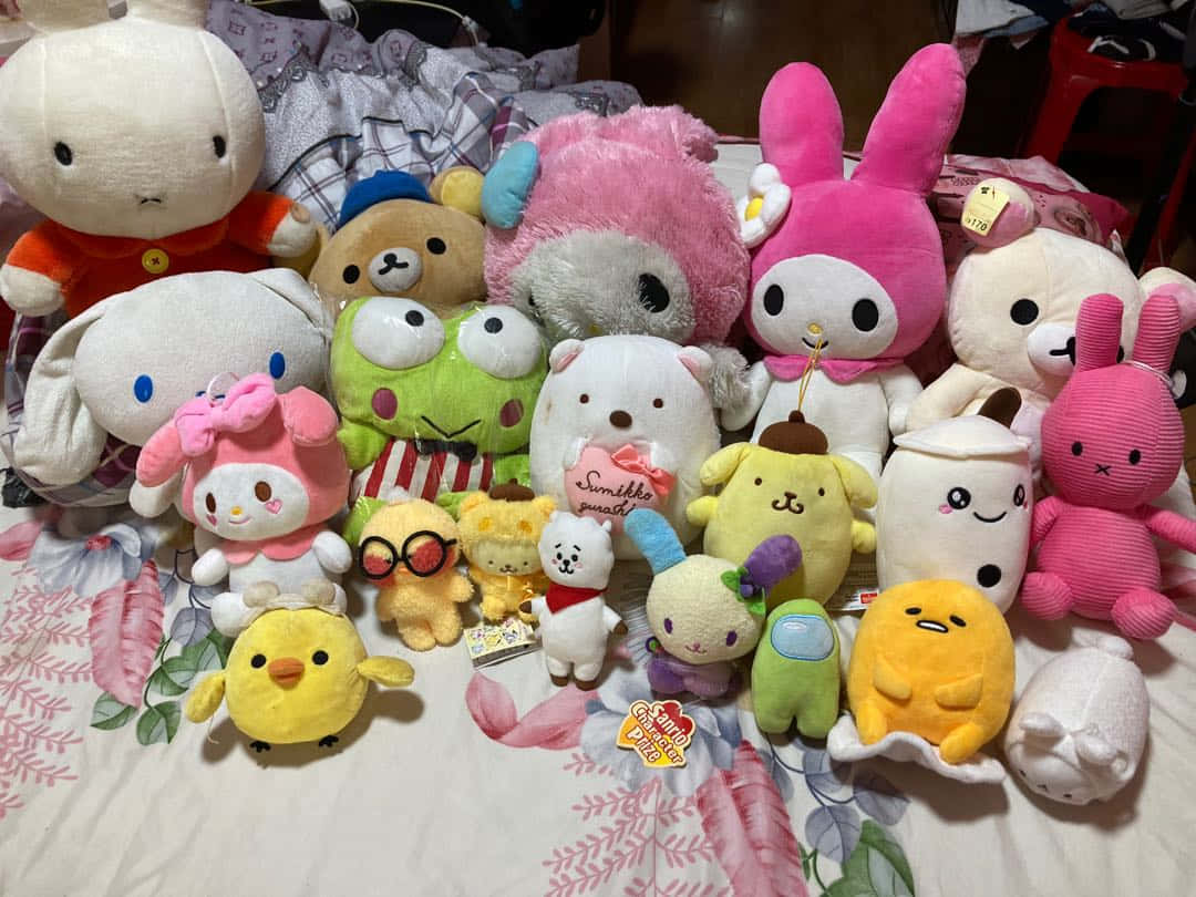 toys 桌布 壁紙 — 一個舒適的彩色毛絨玩具系列，包括My Melody、Keroppi和Gudetama，排列在花卉床罩上。