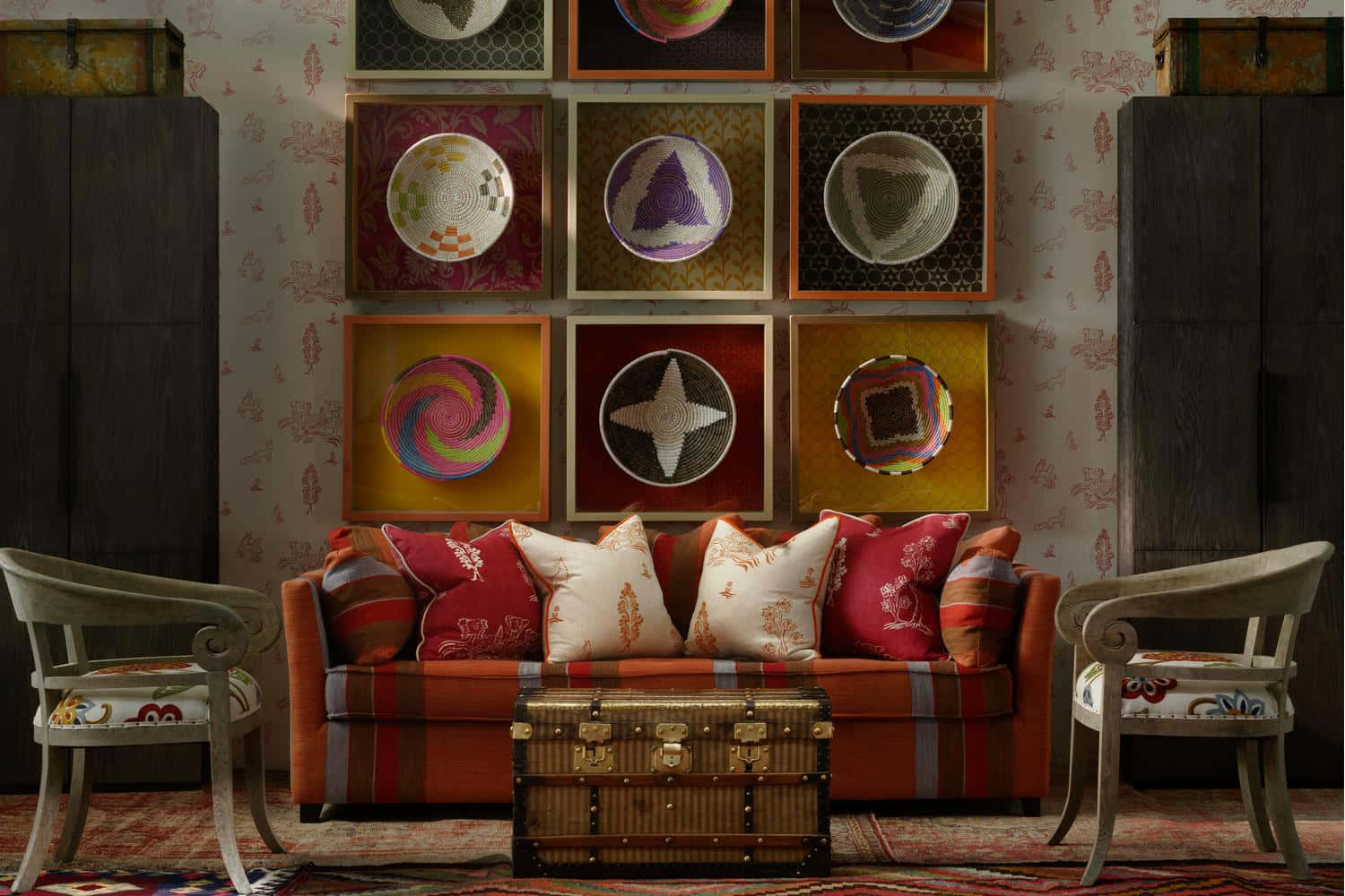 Living Room 桌布 壁紙 — 一個舒適的復古客廳，設有橙色條紋沙發搭配圖案抱枕，兩側是華麗的椅子和一個行李箱咖啡桌，下方是一面色彩繽紛的框裝編織籃子牆。
