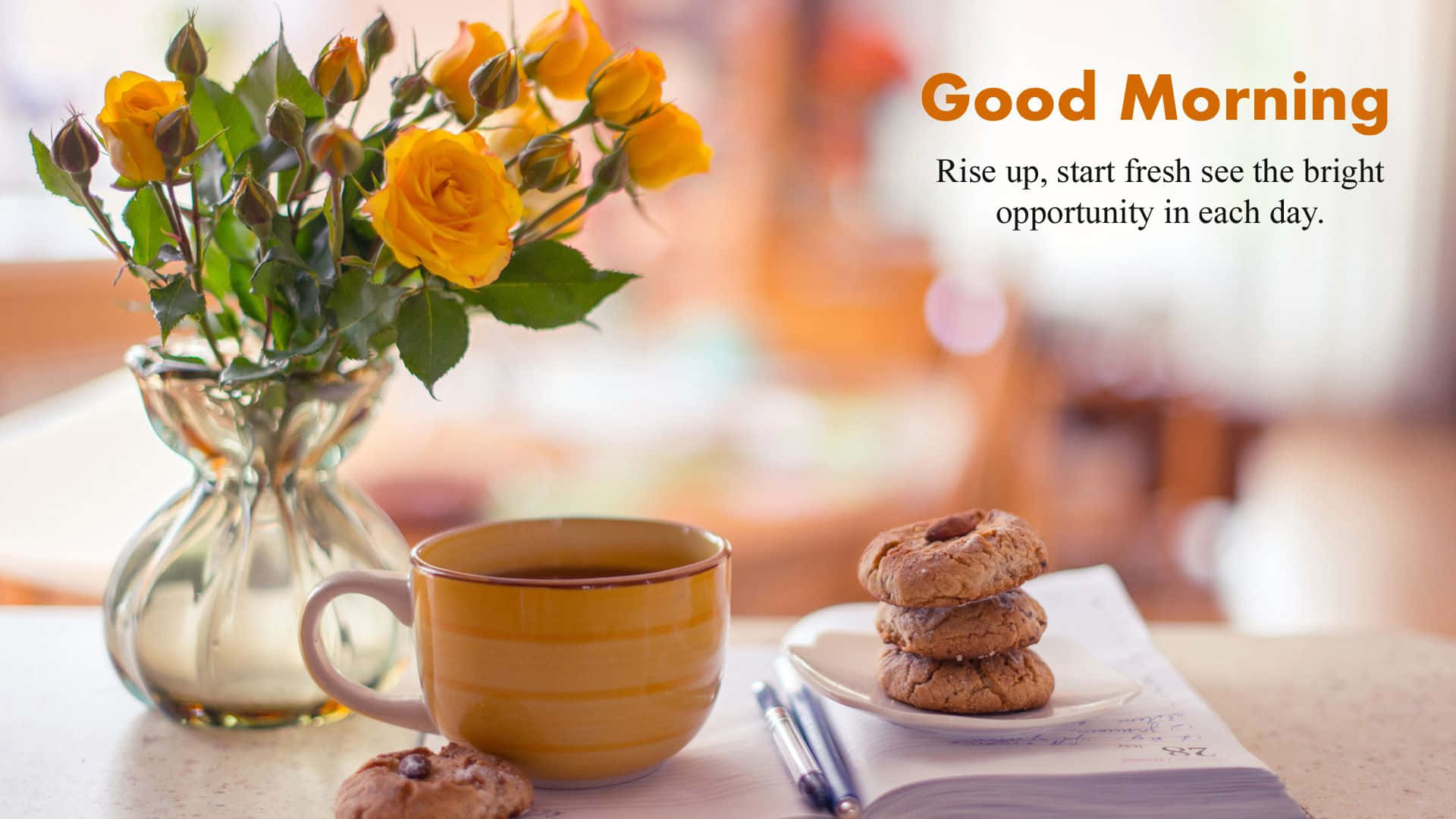 Good Morning 桌布 壁紙 — 一個舒適的早晨場景，黃玫瑰放在玻璃花瓶裡，旁邊有條紋杯、餅乾和一本打開的筆記本在木桌上。