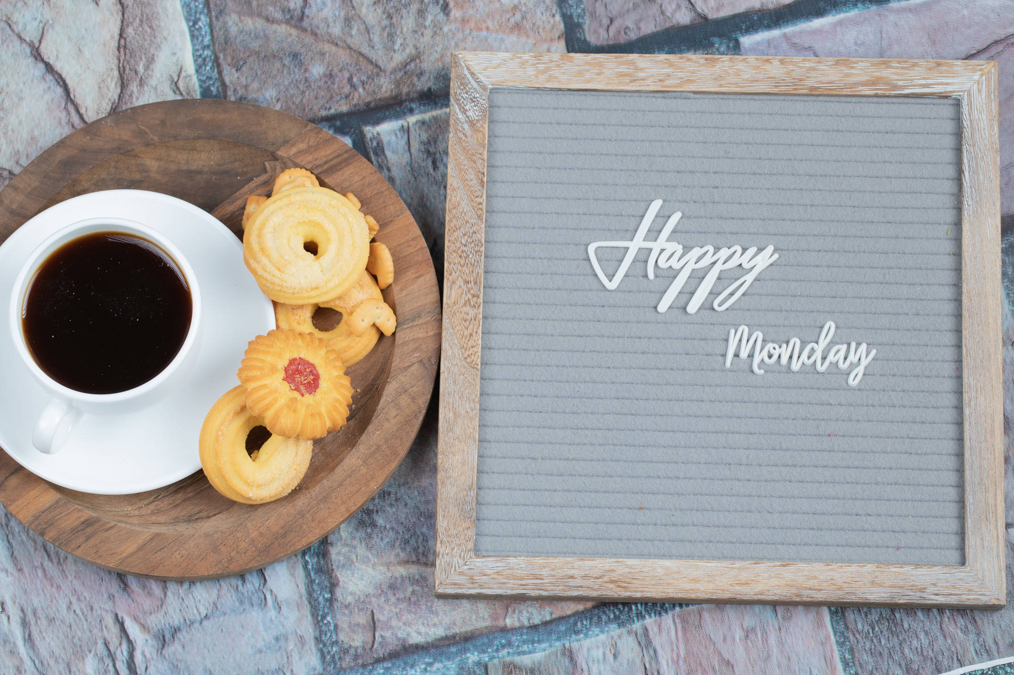 Happy Monday 桌布 壁紙 — 一個舒適的木托盤上放著咖啡和奶油餅乾，旁邊有一個裱框的「Happy Monday」標誌，放在石頭表面上。