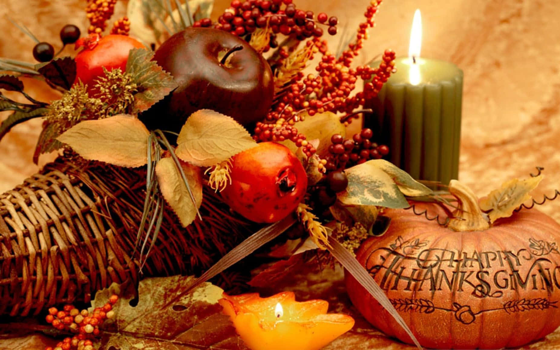 Beautiful Thanksgiving 桌布 壁紙 — 一個舒適的秋季靜物，一個豐收角裝滿蘋果、漿果和樹葉，旁邊有一個雕刻的南瓜和閃爍的蠟燭。