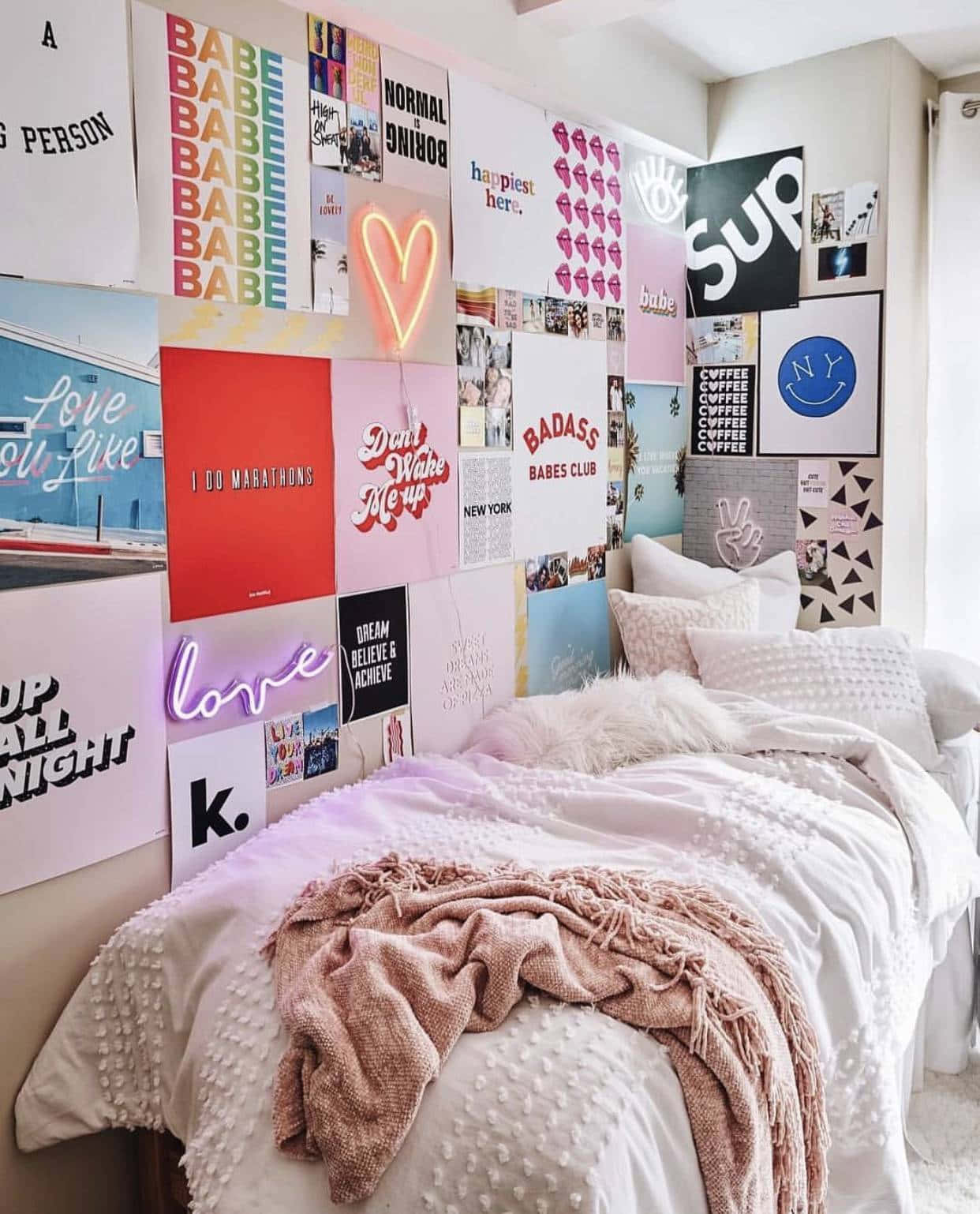 Aesthetic Room 桌布 壁紙 — 一個舒適的臥室，床上鋪有質感的白色和粉紅色毯子，牆上貼滿了海報、霓虹燈標誌和勵志語錄的充滿活力的拼貼畫。