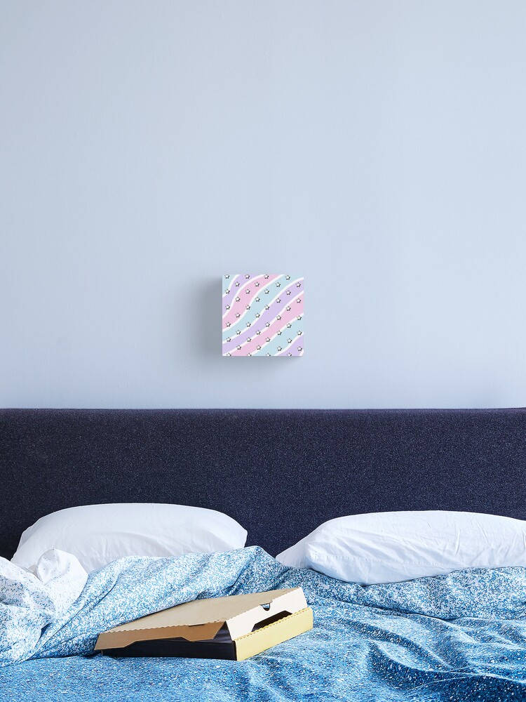 Blue Pastel Aesthetic 桌布 壁紙 — 一個舒適的臥室場景，配有藍色圖案床、白色枕頭，以及牆上色彩繽紛的抽象藝術品。