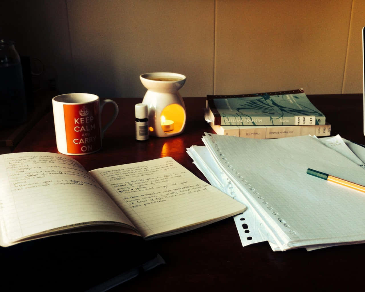 Studying 桌布 壁紙 — 一個舒適的辦公桌設置，配有打開的筆記本、冒著熱氣的馬克杯和溫暖發光的精油擴香器，沐浴在柔和的午後光線中。