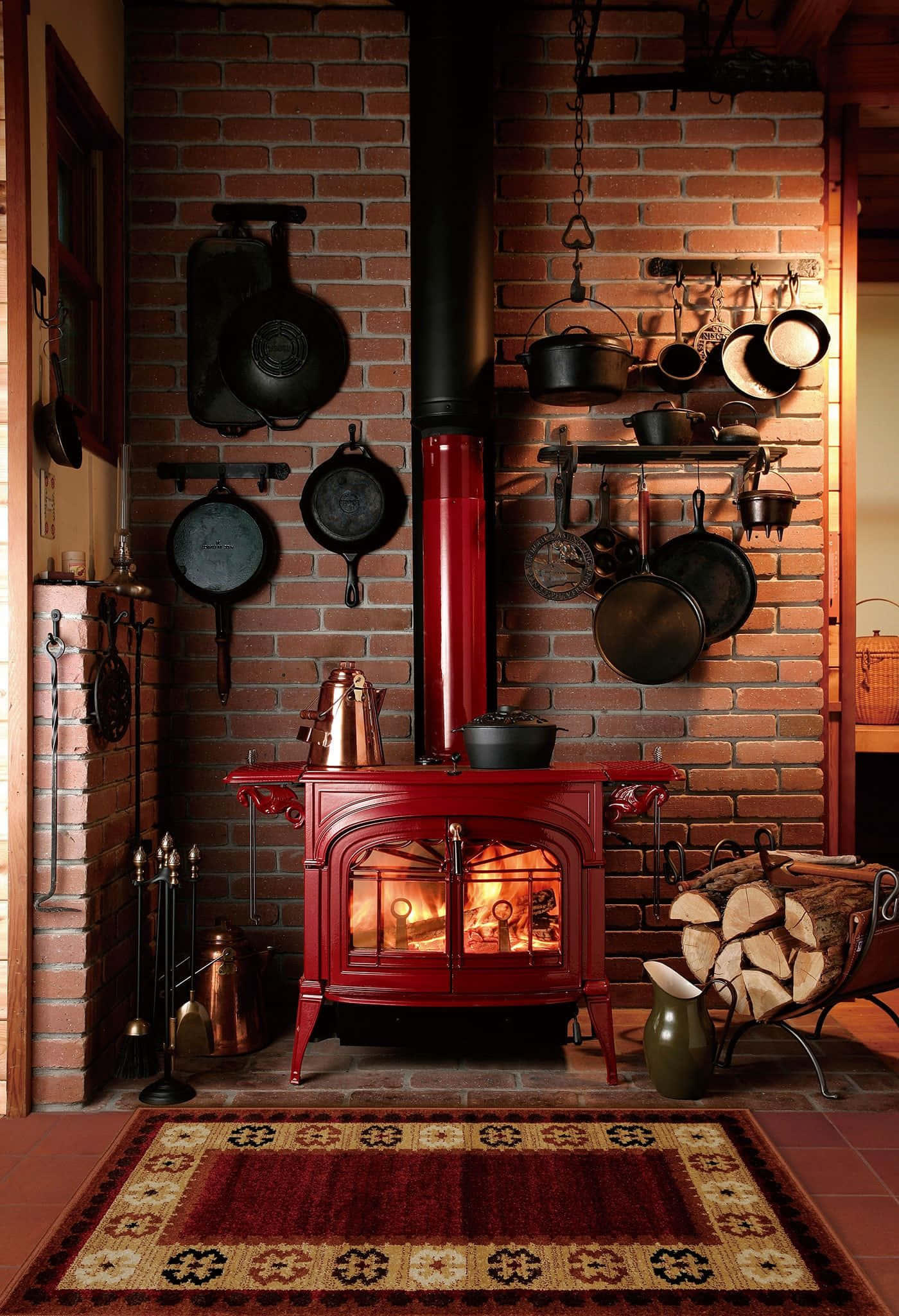 Stove 桌布 壁紙 — 一個舒適的鄉村風格廚房，帶有發光的紅色柴火爐，磚牆上掛著鑄鐵炊具。