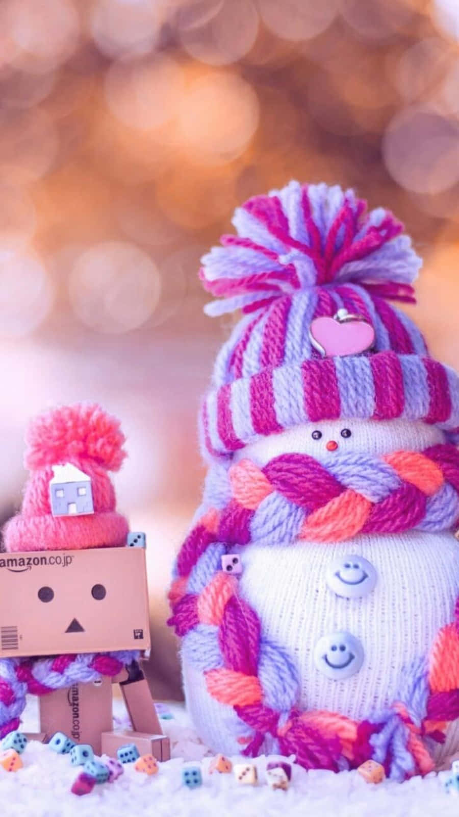 聖誕節 桌布 壁紙 — 一個舒適的針織雪人，戴著條紋帽子和圍巾，站在一個小雪白粉末中的小紙板機器人旁邊。