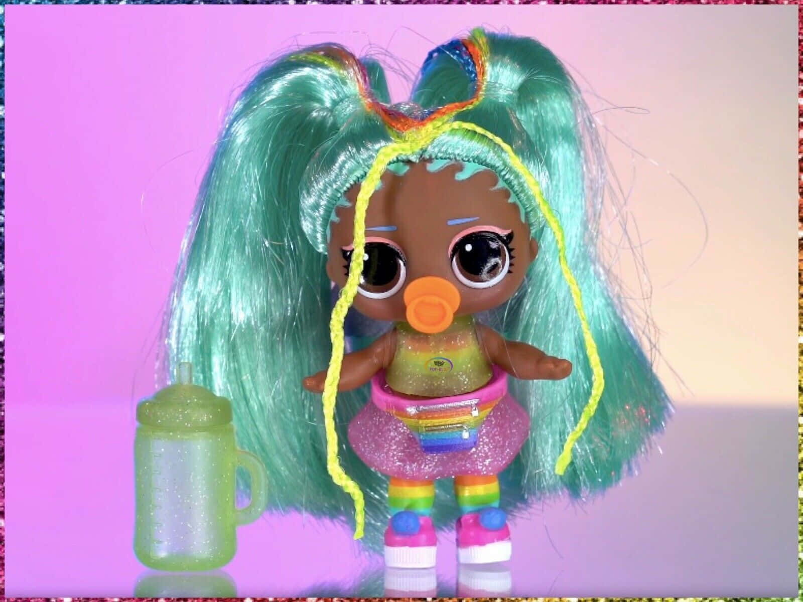 Lol Doll 桌布 壁紙 — 一個色彩繽紛、擁有彩虹色頭髮和奶嘴的娃娃，站在一個閃閃發光的綠色瓶子旁邊，背景是粉紅色漸變色。