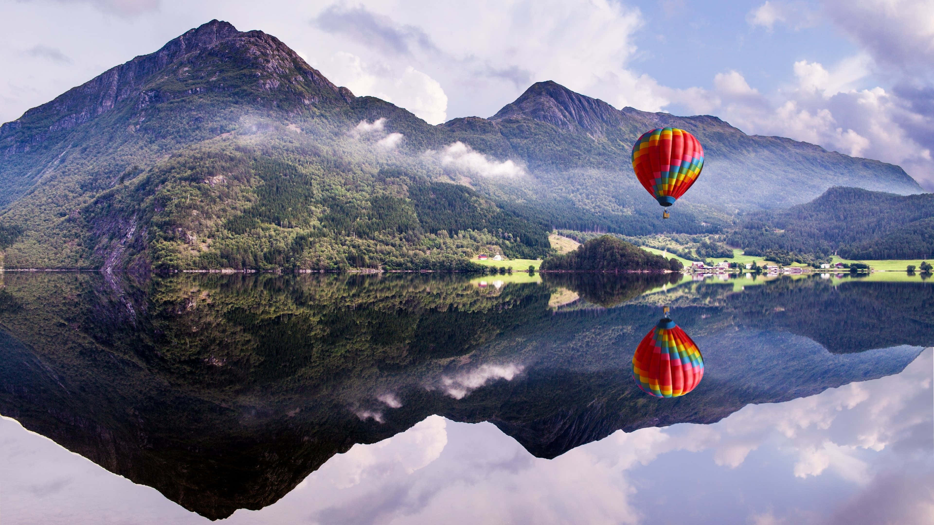 Hot Air Balloon 桌布 壁紙 — 一個色彩繽紛的熱氣球漂浮在寧靜的山湖上空，完美地映照出天空和山峰。