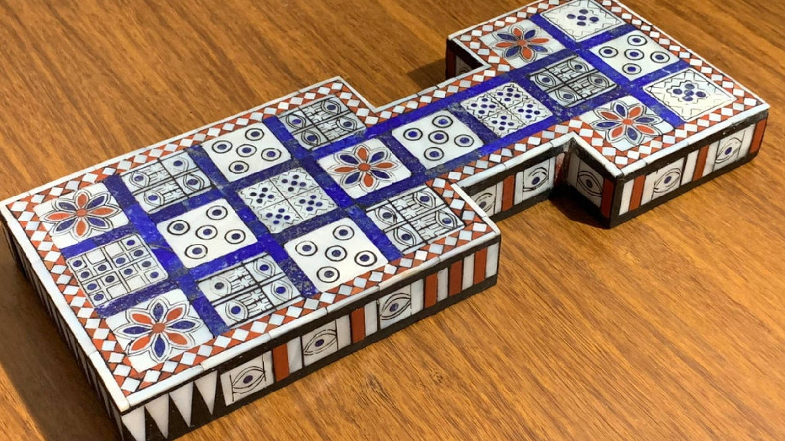 Playing Cards 桌布 壁紙 — 一個色彩繽紛的馬賽克瓷磚雕塑，形狀像字母 T，放置在溫暖的木質表面上。