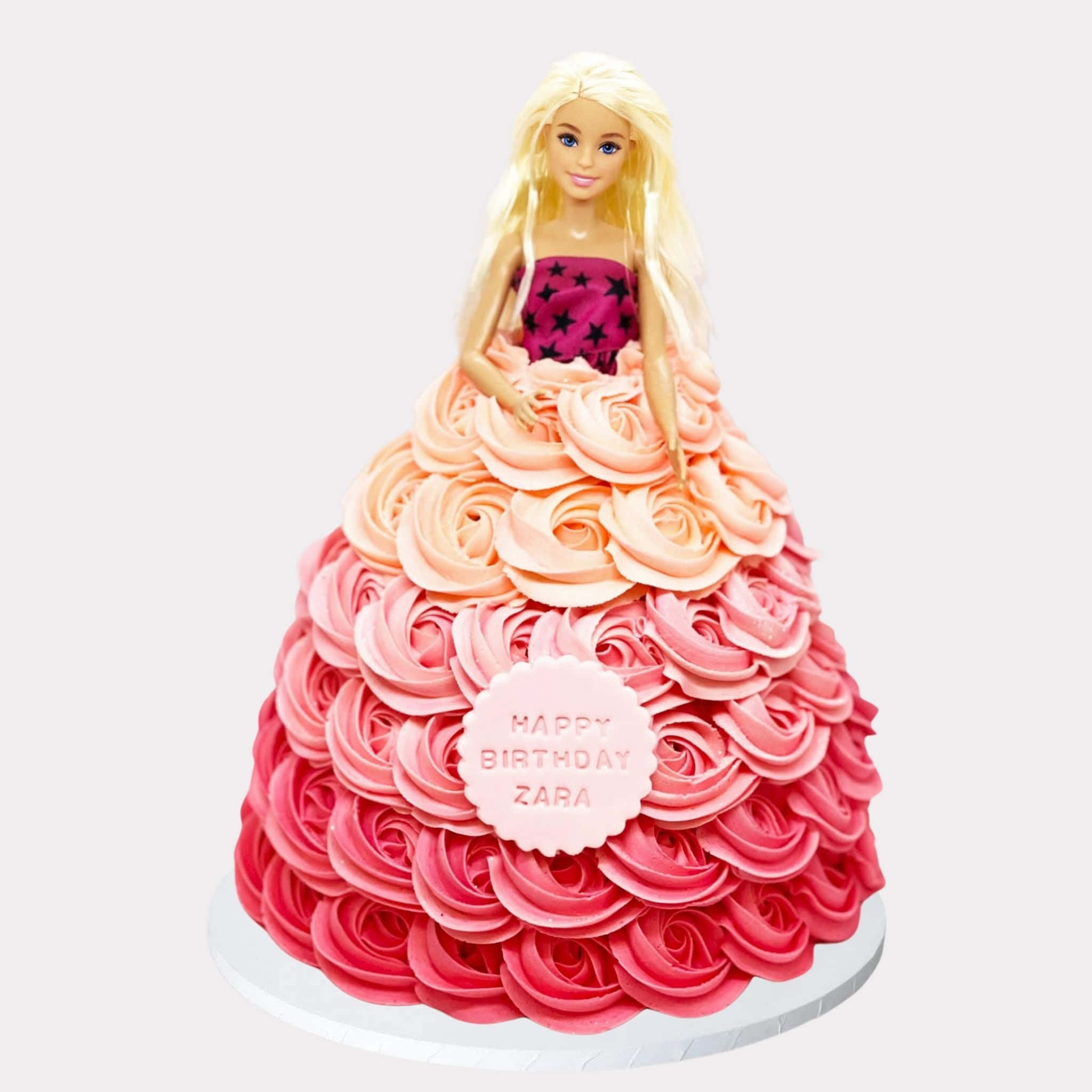 Barbie Doll 桌布 壁紙 — 一個芭比娃娃公仔坐在一個裝飾有粉紅色玫瑰糖霜瀑布和「Happy Birthday Zara」牌的蛋糕上。