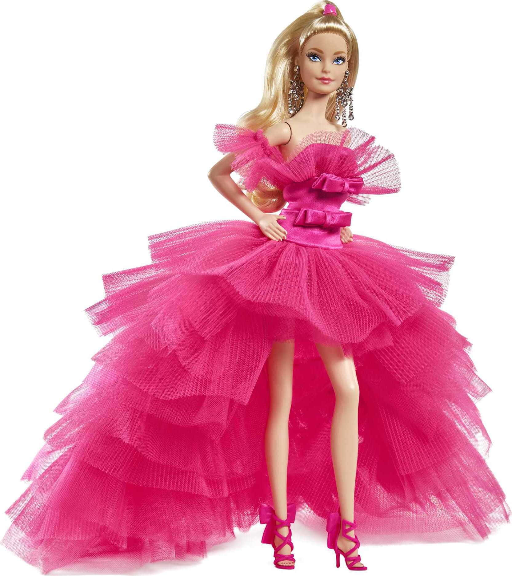 Barbie Doll 桌布 壁紙 — 一個芭比娃娃穿著充滿活力的桃紅色薄紗連衣裙，帶有荷葉邊和相配的高跟鞋，在白色背景前自信地擺姿勢。