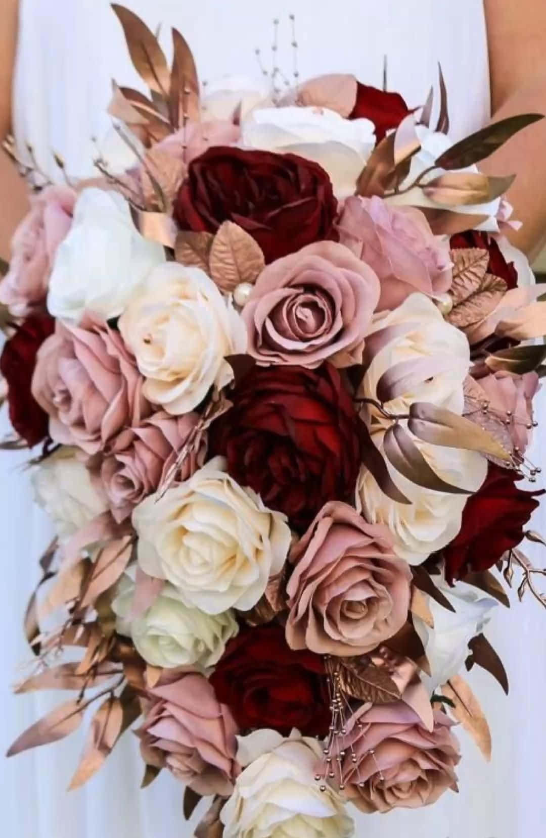 Roses Wedding 桌布 壁紙 — 一個茂盛的新娘花束，由深紅色腮紅和奶油色玫瑰組成，並以銅葉和珍珠珠子點綴。