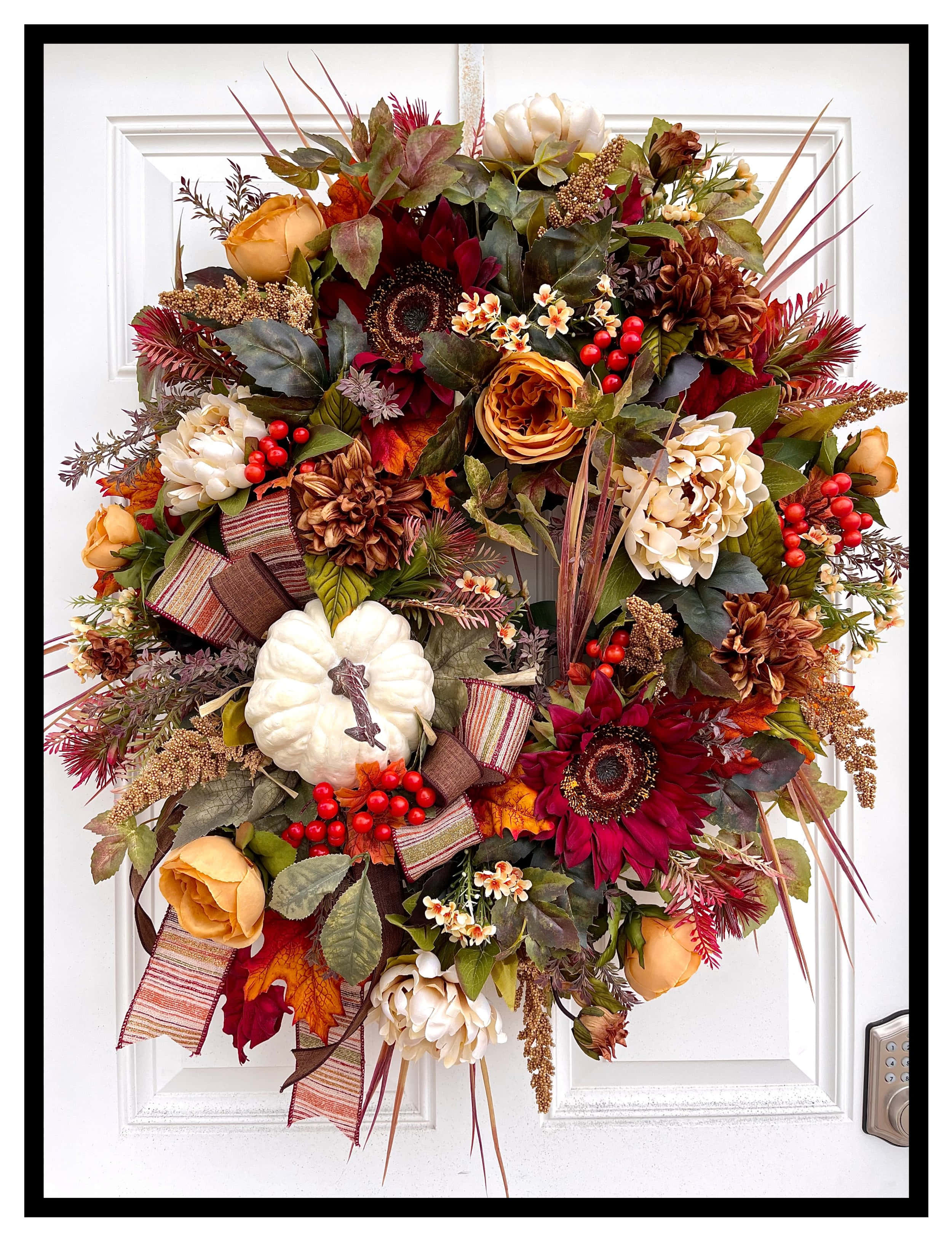 Fall Wreath 桌布 壁紙 — 一個茂盛的秋季花環，裝飾著南瓜、漿果和色彩豐富的樹葉，掛在白色的前門上。