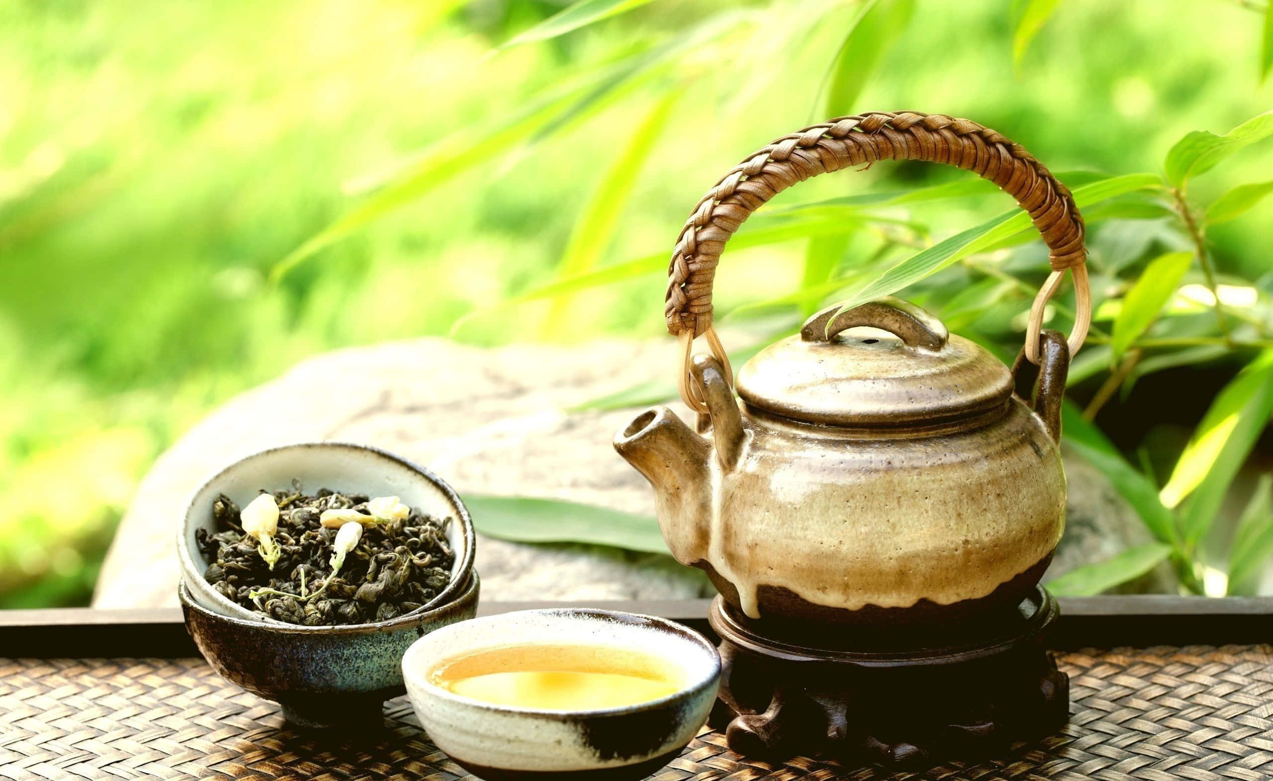 一個茶壺附茶葉與一杯茶 壁紙