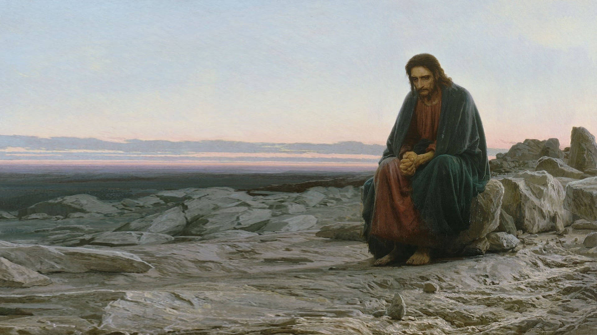 Christ 桌布 壁紙 — 一個莊嚴的人物在黃昏時跪在岩石山頂上，凝視著柔和的粉彩天空下的廣闊風景。