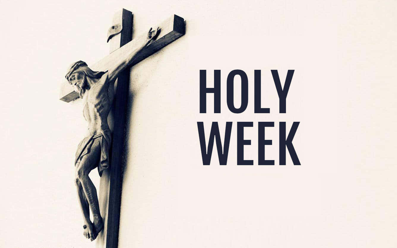 Holy Week 桌布 壁紙 — 一個莊嚴的耶穌石製 crucifixion 雕像掛在素牆上，旁邊有粗體黑色文字寫著「HOLY WEEK」。