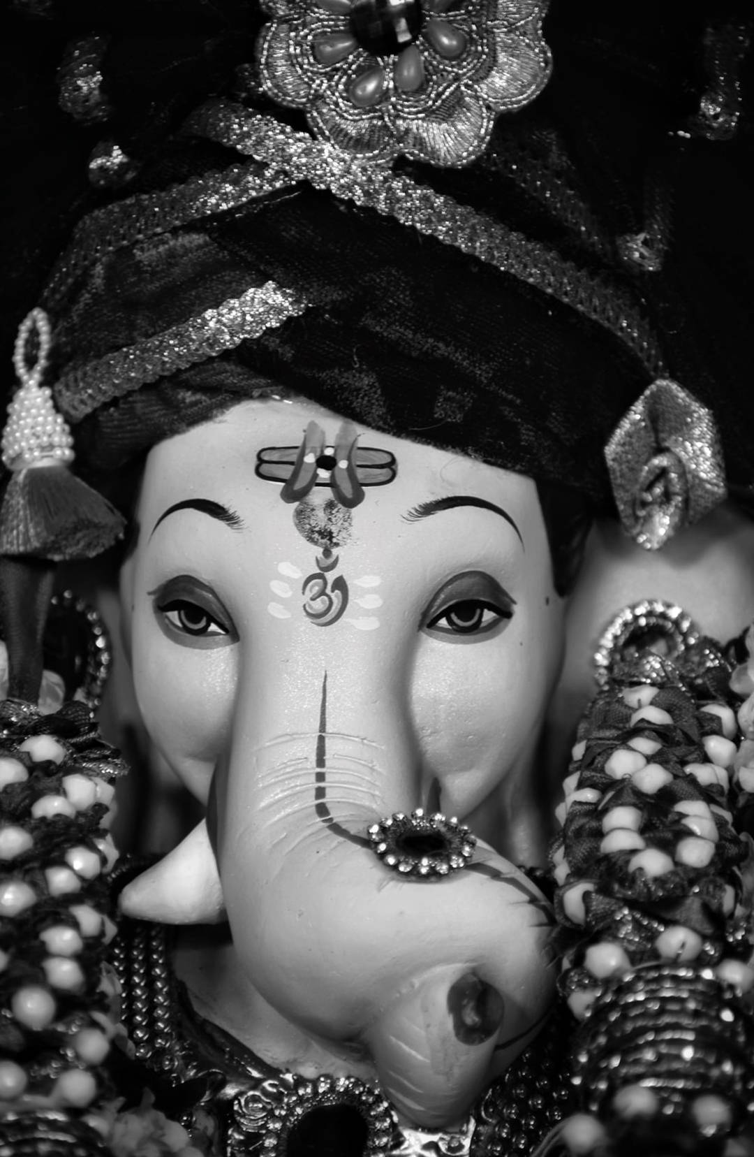 Ganesh 桌布 壁紙 — 一個華麗的象神雕像的特寫黑白肖像，飾有精緻的珠寶和珠子。
