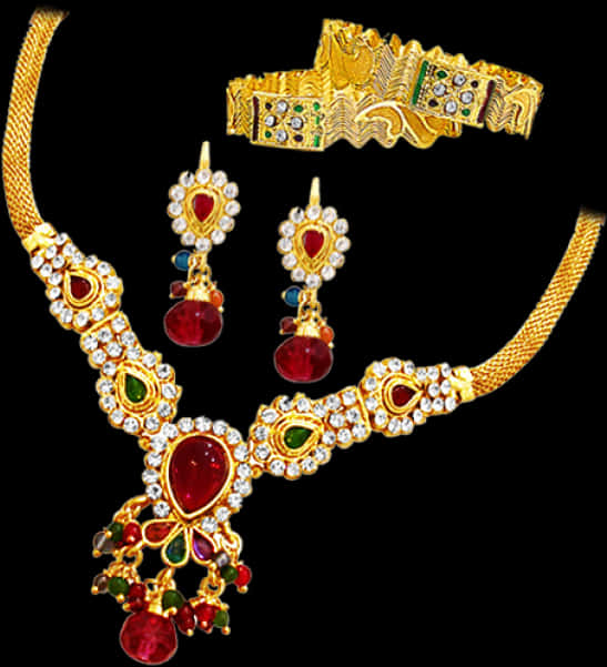 Indian Jewellery 桌布 壁紙 — 一個華麗的金色珠寶套裝，鑲有紅色、綠色和白色寶石，展示在黑色背景上。