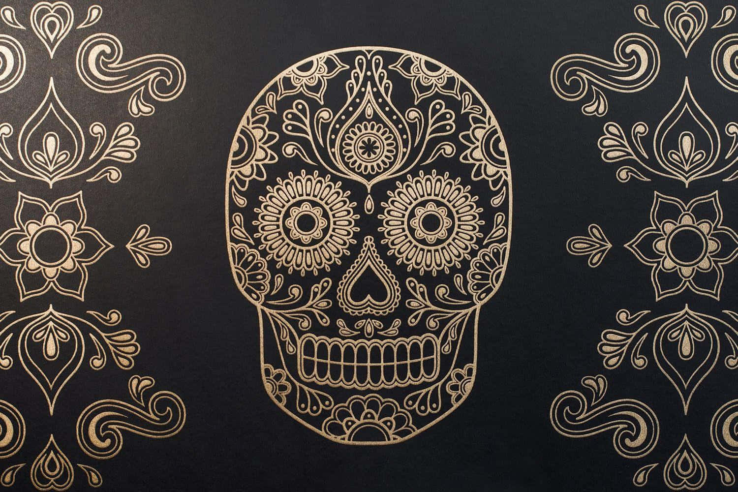 Day Of The Dead 桌布 壁紙 — 一個華麗的金色糖骷髏，帶有複雜的花卉圖案，位於深色背景中央，兩側有對稱的裝飾圖案。