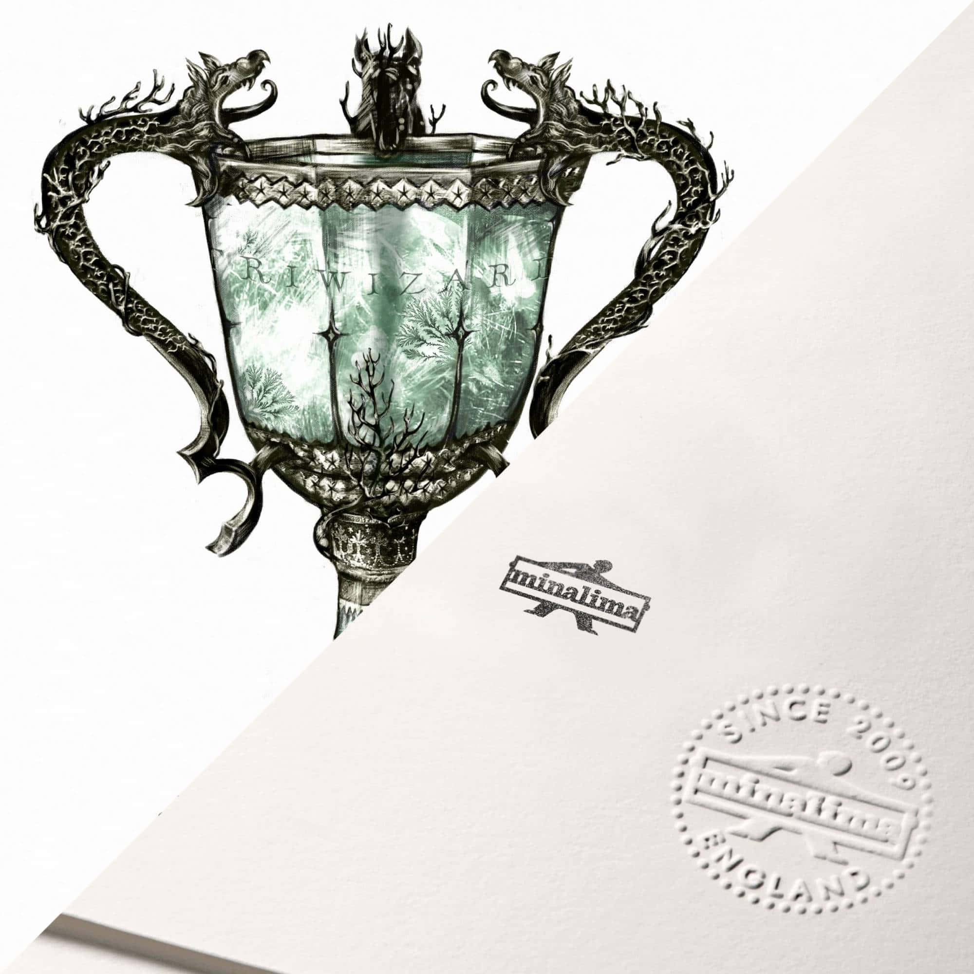 The Triwizard Cup 桌布 壁紙 — 一個華麗的銀色獎盃，帶有龍形把手，內部有森林場景，放置在帶有壓花品牌的紋理紙上。