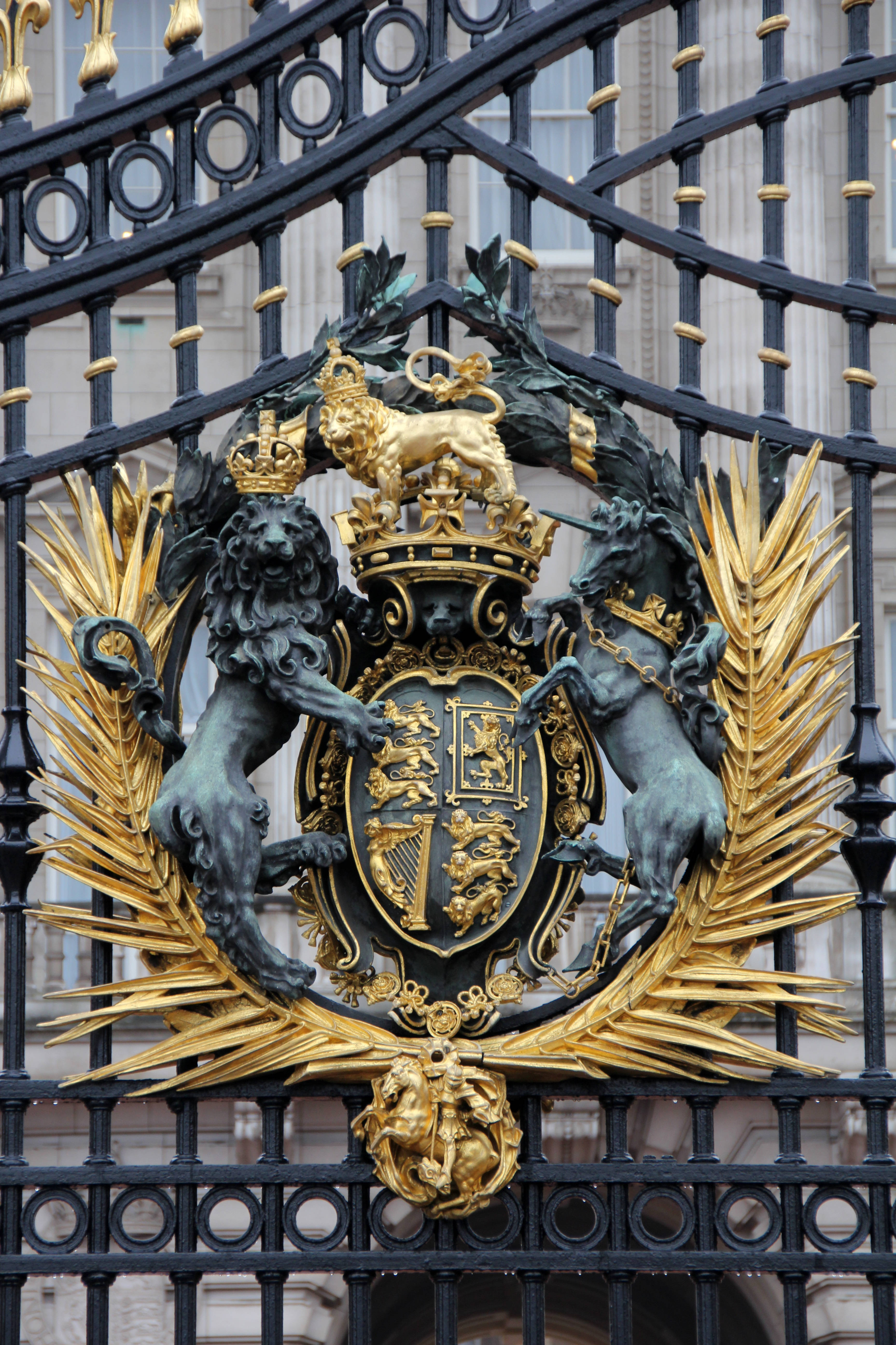 England 桌布 壁紙 — 一個華麗的黑色鐵門特寫，上面有一個金色的皇家徽章，兩側有兩隻獅子和一隻獨角獸守護著盾牌。