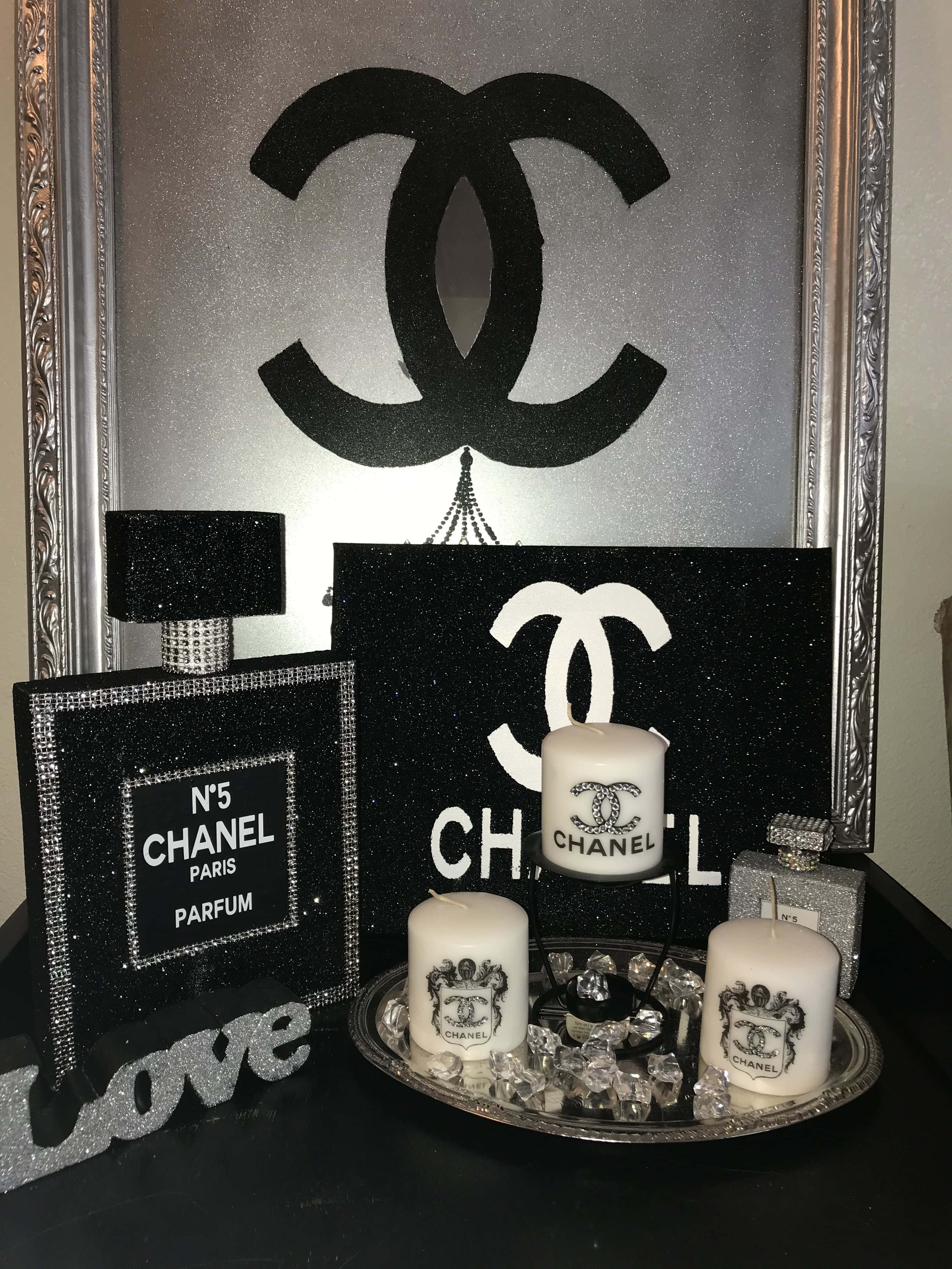香奈兒標誌 桌布 壁紙 — 一個華麗的黑銀色 Chanel 主題裝飾展示，包含閃閃發光的香水瓶、蠟燭和標誌性標誌藝術。