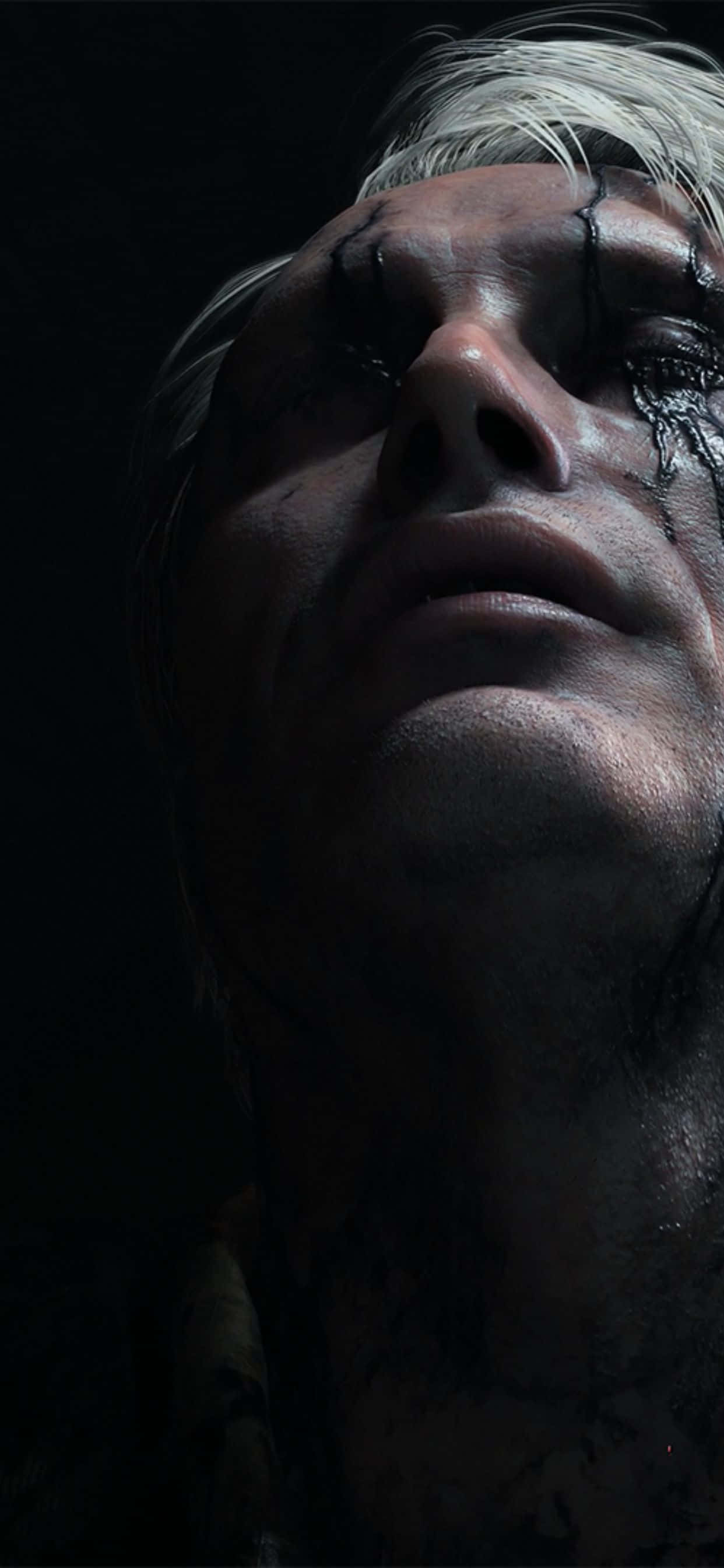 iPhone Xs Max Death Stranding 桌布 壁紙 — 一個蒼白男人的特寫，白髮和深色條紋流過他的臉，場景昏暗。