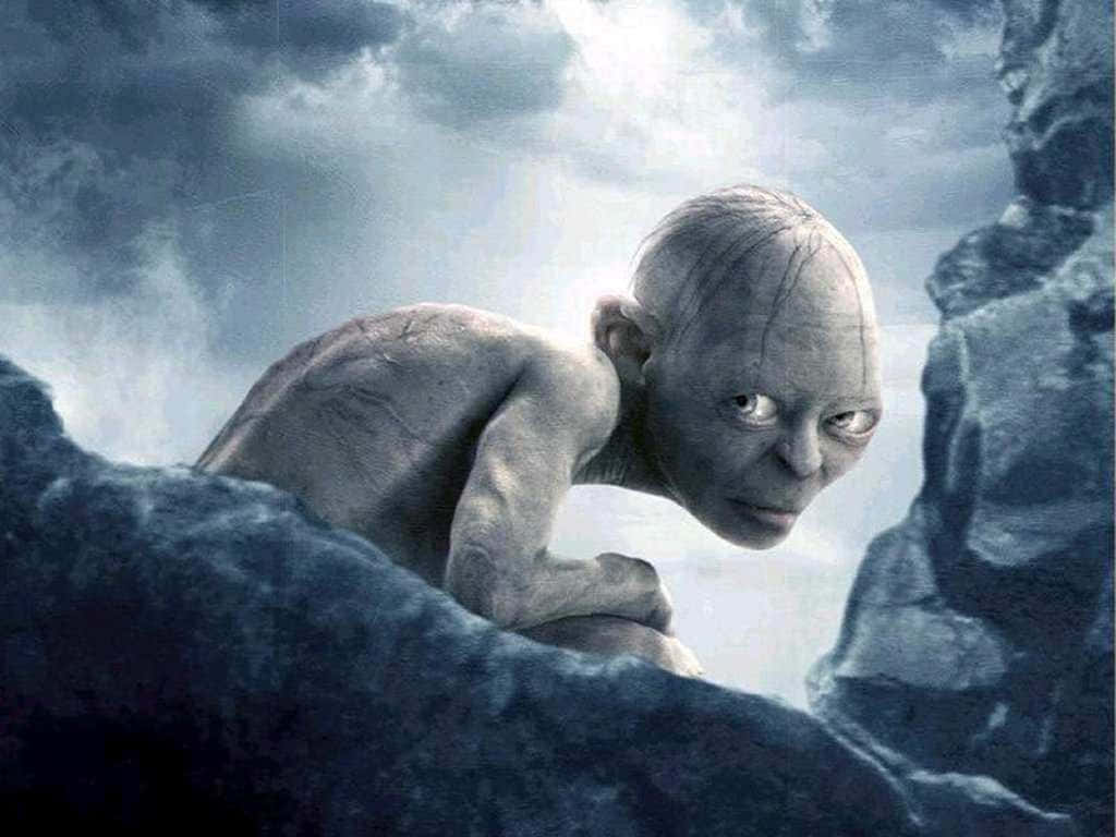Gollum 桌布 壁紙 — 一個蒼白瘦弱的哥布林在暴風雨灰色天空下，從黑色岩石之間窺視。