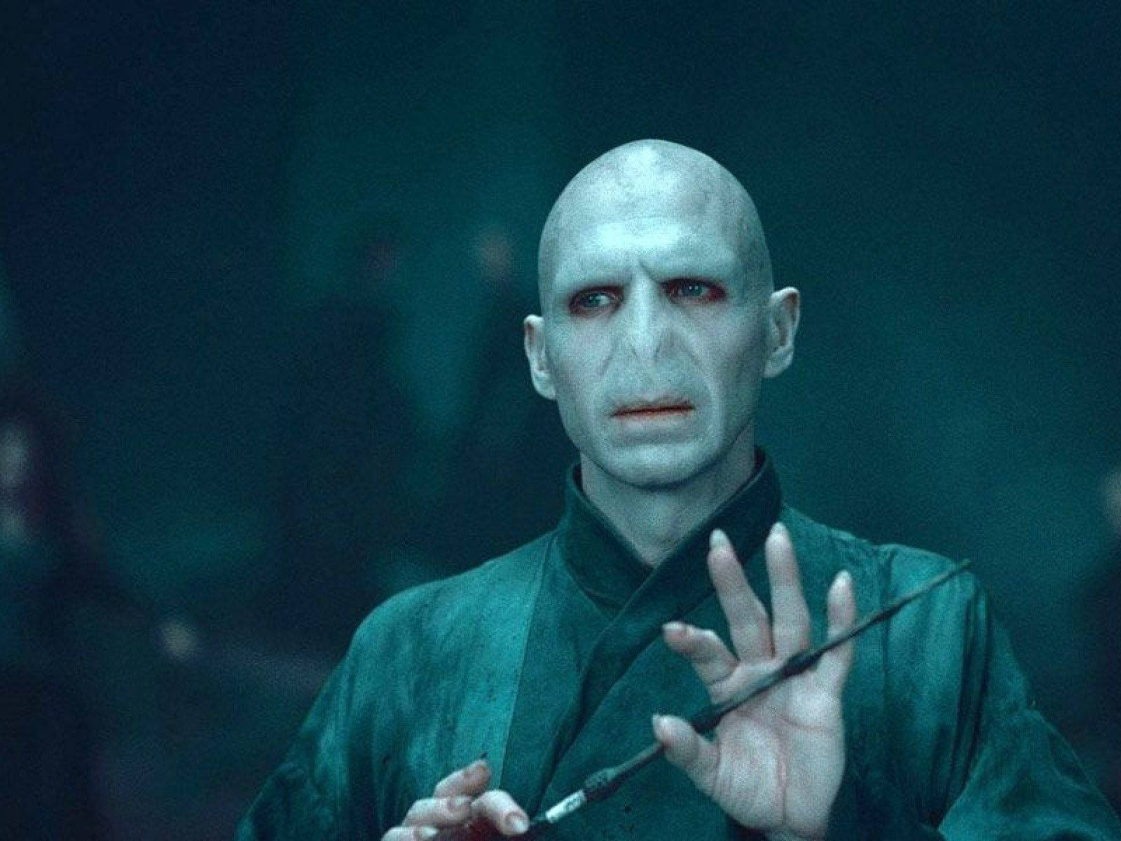voldemort 桌布 壁紙 — 一個蒼白禿頭紅眼的男人在昏暗的青色房間裡拿著魔杖。