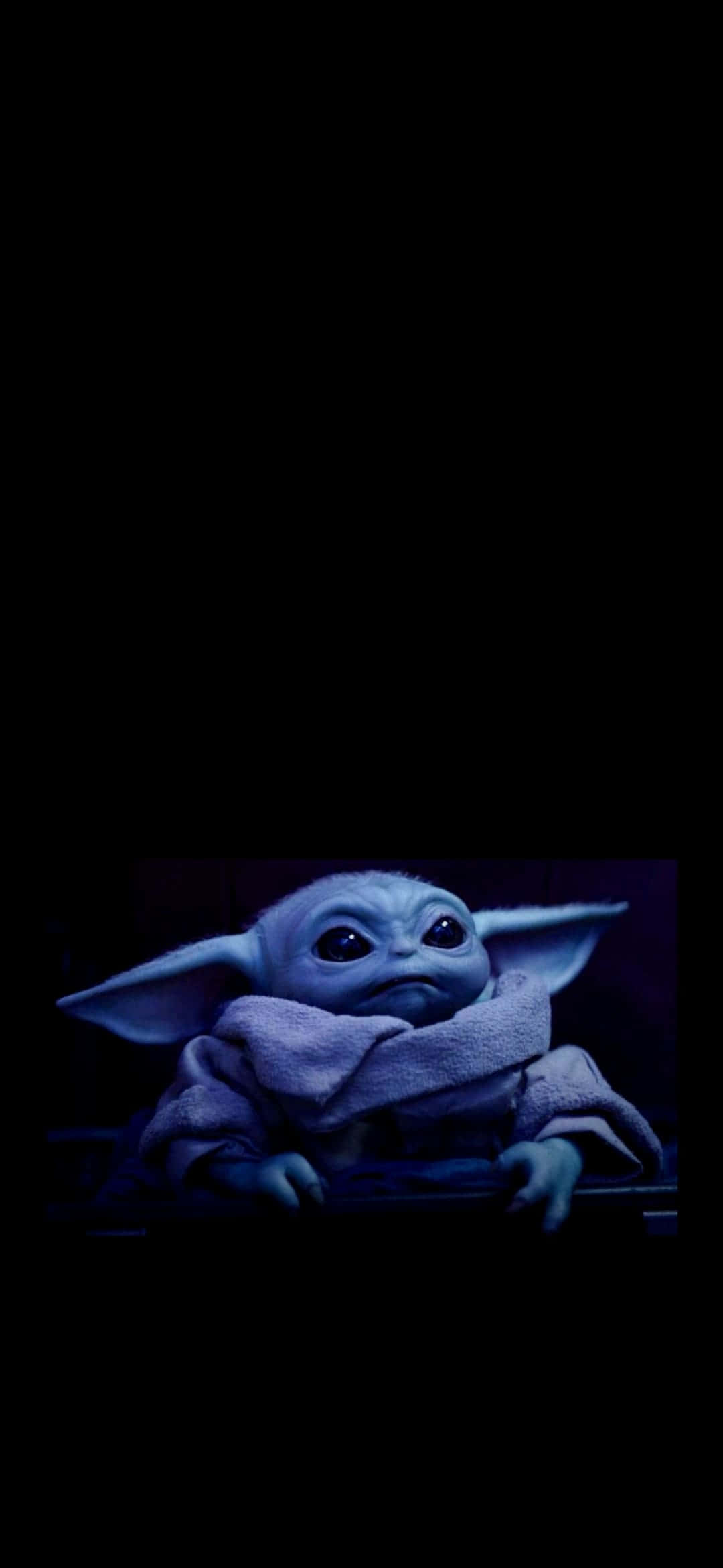 Baby Yoda iPhone 桌布 壁紙 — 一個藍皮膚大耳朵的小外星人，裹著長袍，坐在黑色背景的昏暗藍光下。