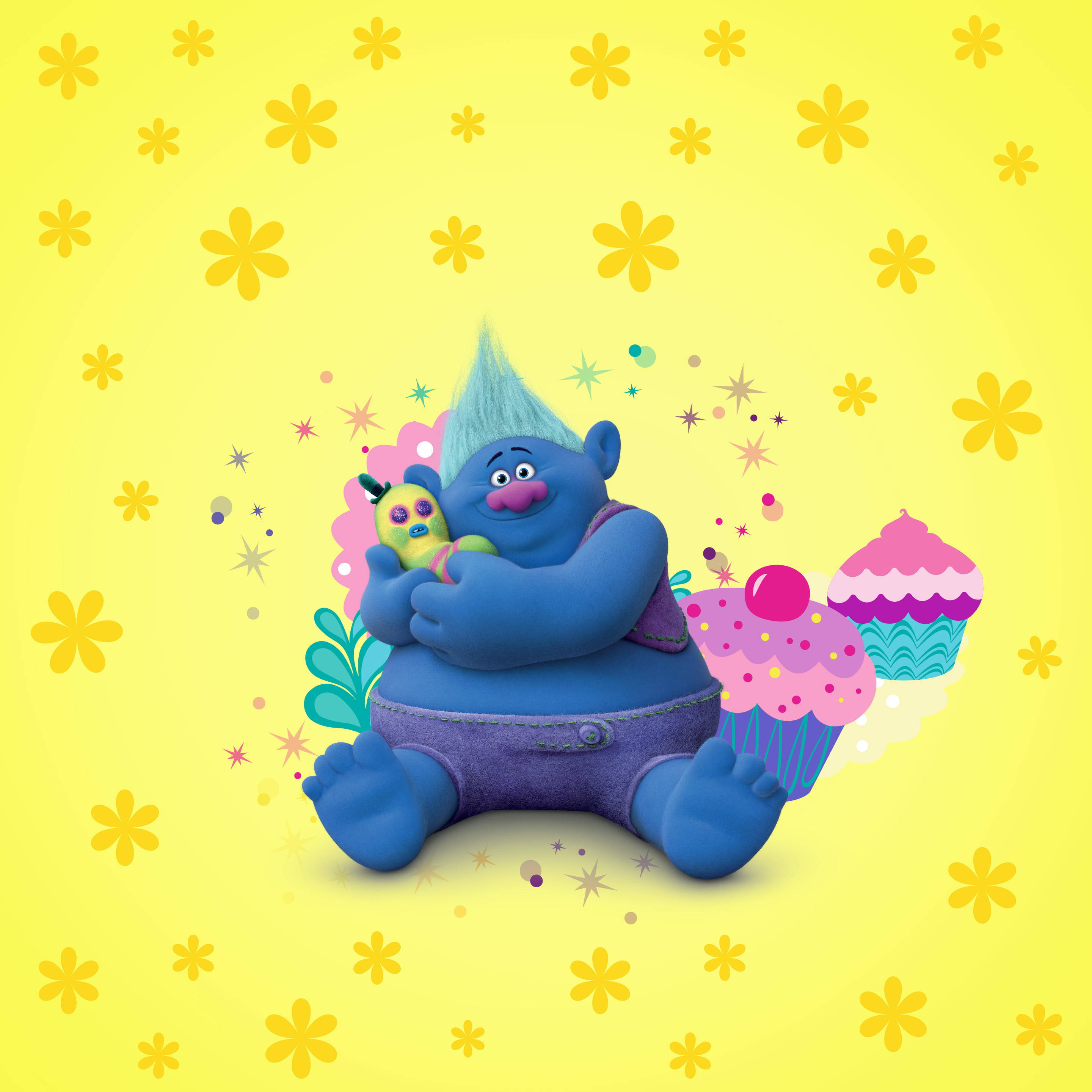 魔髮精靈 桌布 壁紙 — 一個藍色 troll 擁有尖刺的青綠色莫霍克髮型，開心地坐著，拿著一個玩具和一個巨型杯子蛋糕，背景是鮮黃色，上面有漂浮的花朵。