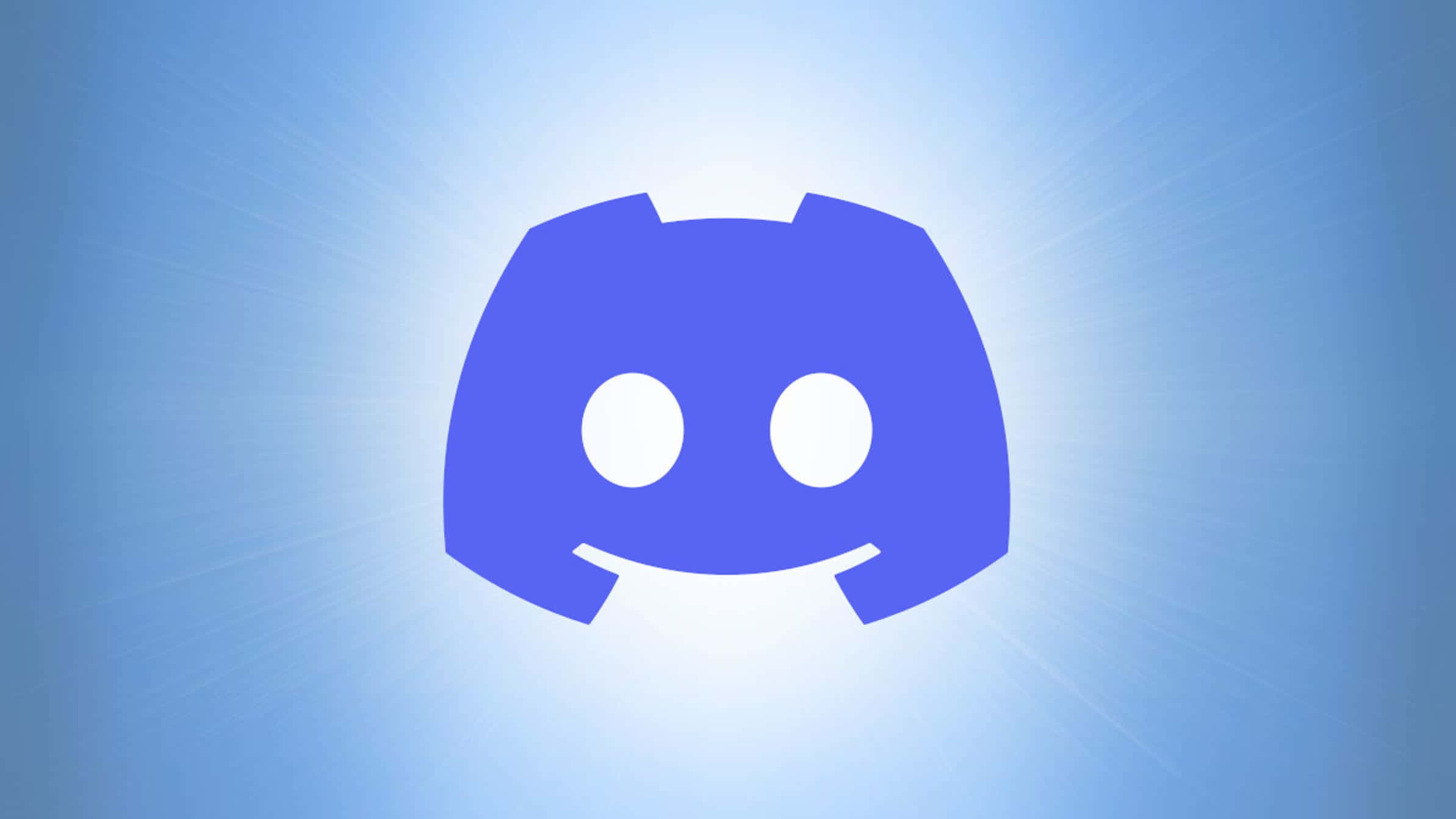 Discord 桌布 壁紙 — 一個藍色Discord標誌，帶有白色眼睛和微笑，在漸變藍色背景和陽光射線中散發光芒。