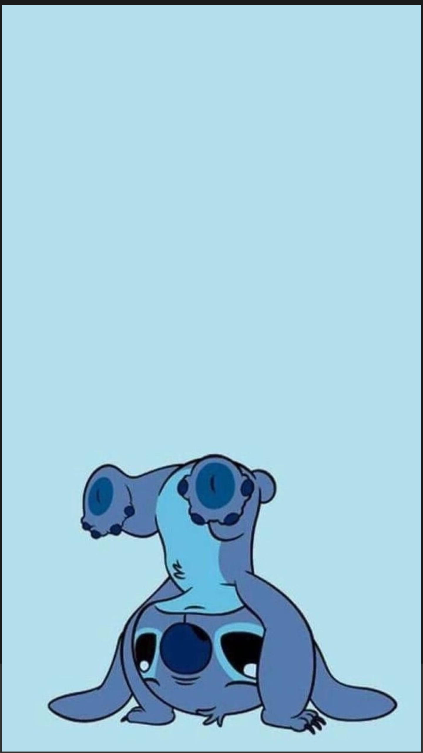 Stitch Disney 桌布 壁紙 — 一個藍色卡通外星人，有大眼睛，獨自坐在純淺藍色背景前。