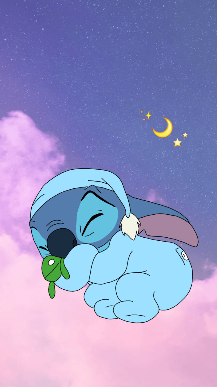 cute disney stitch 桌布 壁紙 — 一個藍色卡通外星人穿著連帽衫，在星空紫色天空下，有新月和粉紅雲朵，安詳地睡著。