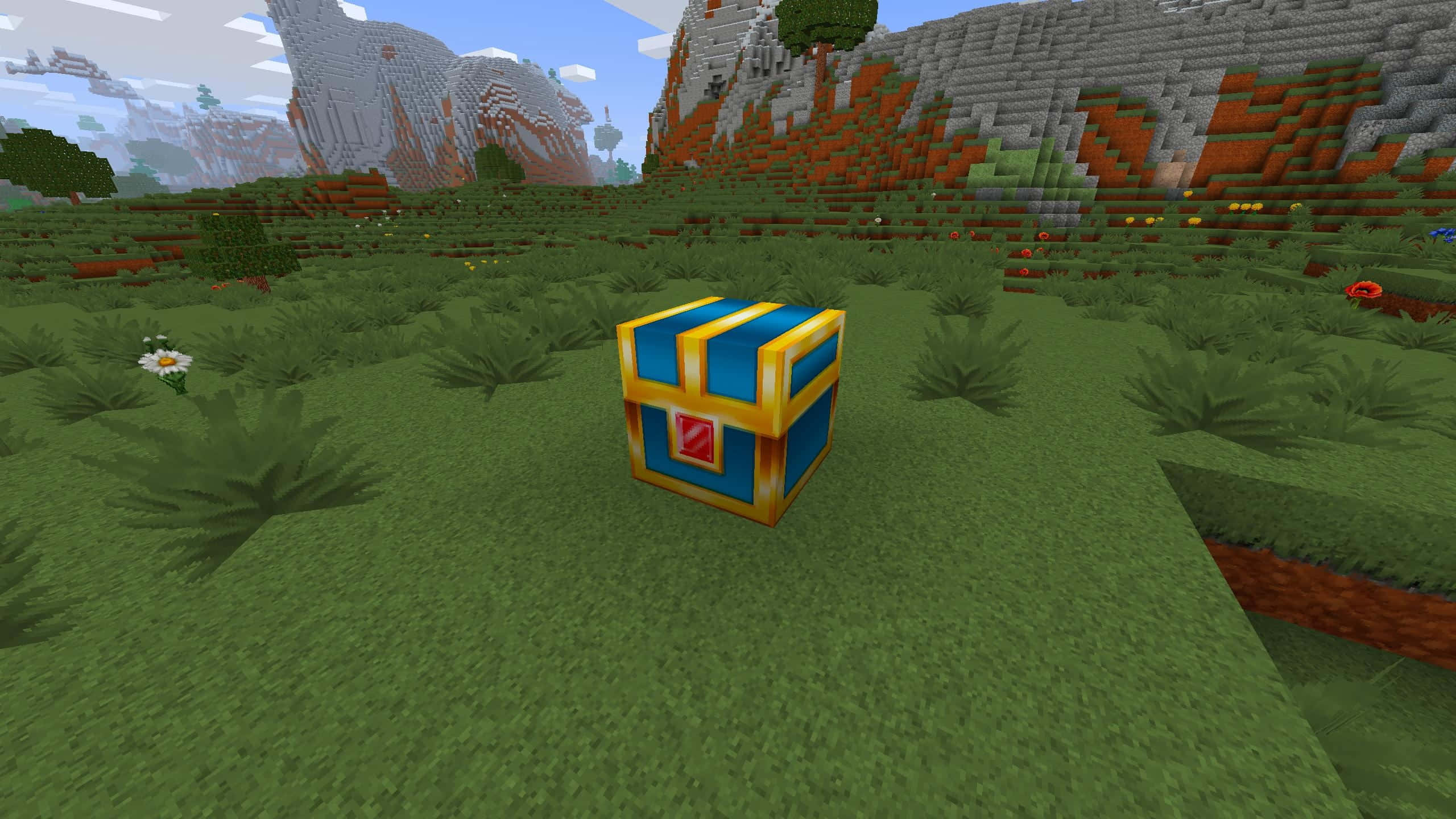 Minecraft Adventure 桌布 壁紙 — 一個藍色和金色的寶箱放在一個草地的Minecraft田野中，有塊狀的山脈和樹木，天空明亮。
