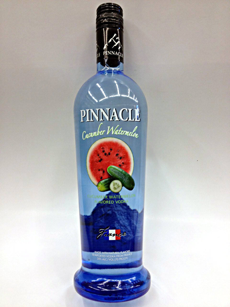 bottle 桌布 壁紙 — 一個藍色玻璃瓶的 Pinnacle 青瓜西瓜味伏特加酒，放在純白色背景前。