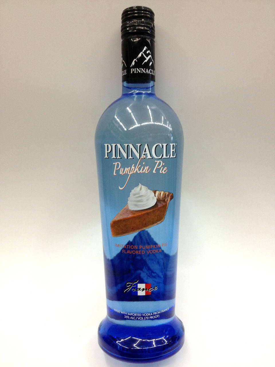 bottle 桌布 壁紙 — 一個藍色瓶子的Pinnacle Pumpkin Pie口味伏特加，立在純白色背景前。