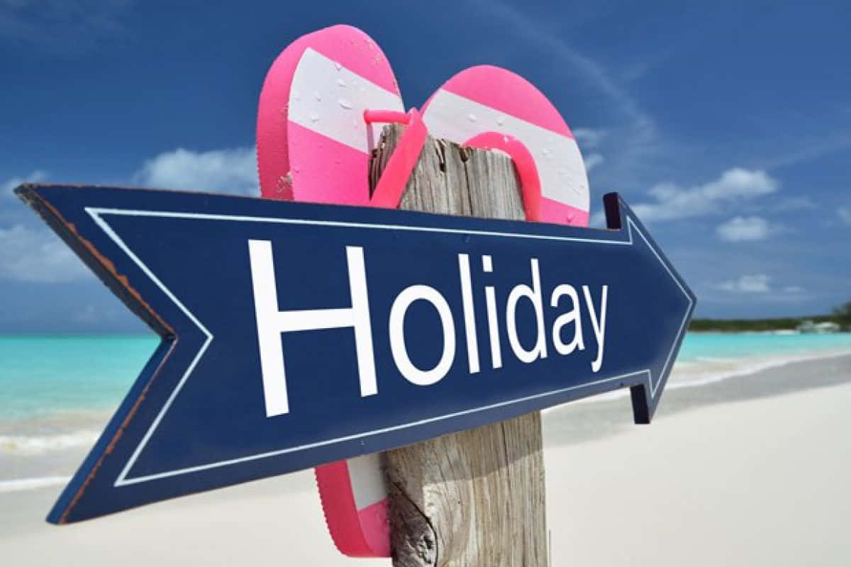 節日 桌布 壁紙 — 一個藍色箭頭標誌寫著 Holiday，指向一個藍綠色海灘，木柱上放著粉紅色人字拖。