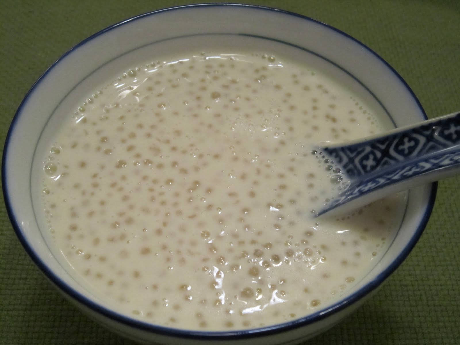 Soup 桌布 壁紙 — 一個藍邊碗中的奶油白色木薯布丁特寫，裡面放著一隻有圖案的湯匙。