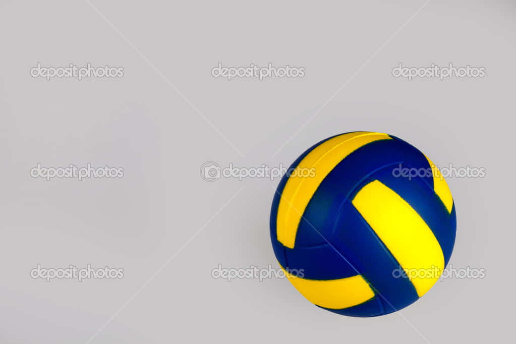 Volleyball Ball 桌布 壁紙 — 一個藍黃色的排球放在帶有柔和陰影的淺灰色平面上。